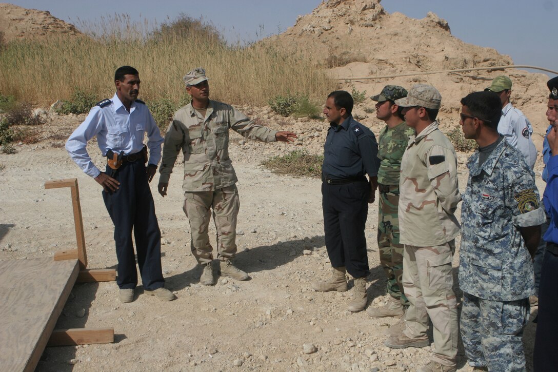 Petty Officer 3rd Class Ramzi Zinnekah, 34, from Palm Springs, Calif., who is an electronics technician with Riverine Squadron 3, Detachment 2, 3rd Battalion, 7th Marine Regiment, Regimental Combat Team 5, talks with a class of Iraqi policemen who are being trained to perform water patrol missions at Lake Qadisiyyah, Iraq, Oct 8. Zinnekah speaks Arabic and translates most of the curriculum into Arabic so the Iraqi Police in the class can understand. ::r::::n::