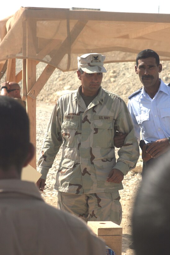 Petty officer 3rd Class Ramzi Zinnekah, 34, from Palm Springs, Calif., who is an electronics technician with Riverine Squadron 3, Detachment 2, 3rd Battalion, 7th Marine Regiment, Regimental Combat Team 5, speaks to a group of Iraqi policemen at Lake Qadisiyyah, Iraq, Oct 8.  A former investment banker, Zinnekah, who speaks Arabic, joined the military to get involved in Iraq and has since helped train Iraqi policemen with his fellow Riverines. ::r::::n::