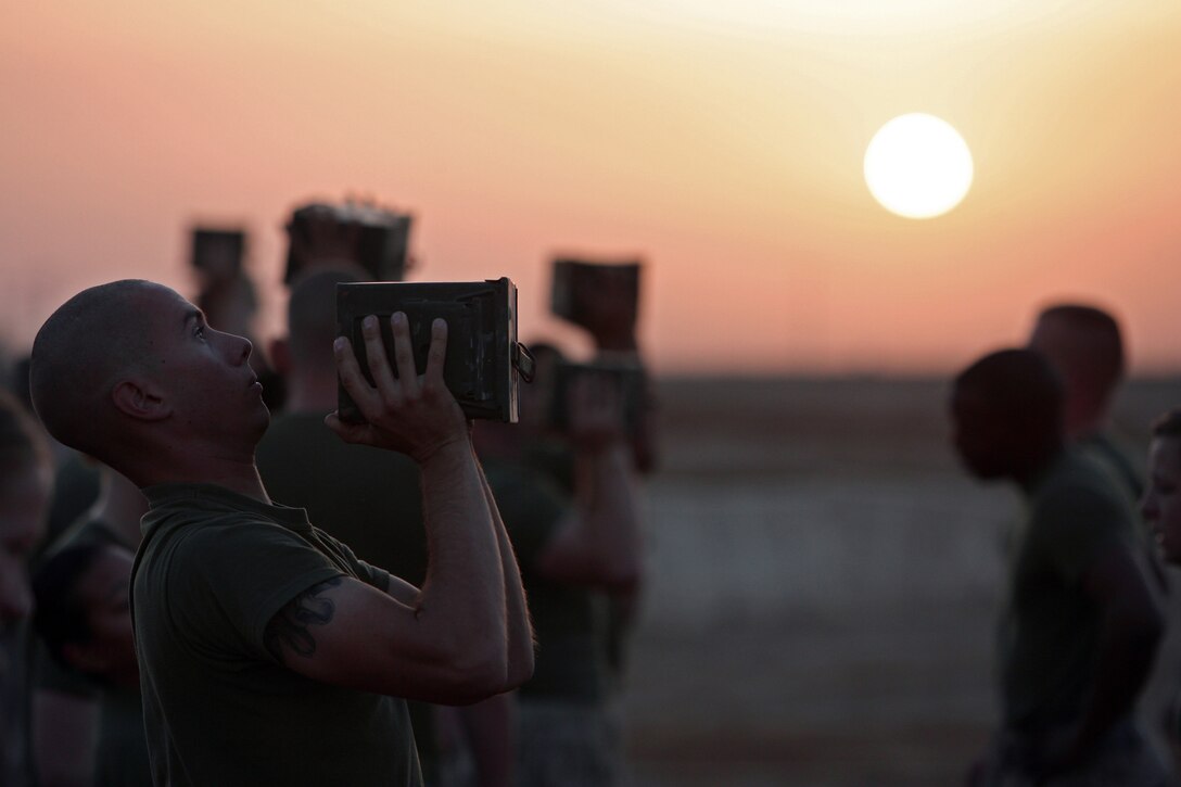 Lance Cpl. Tim D. Dueker, motor transport operator, Truck Company, Marine Expeditionary Force Headquarters Group, I MEF (Forward), keeps a calm face during the ammunition-can press portion of the Combat Fitness Test here Oct. 9, 2008. Dueker and the other Marines in the company were the first group in the forward deployed MHG element to take the test for an official score during the CFT's initial phase-in period. The CFT events combine muscle, agility and endurance to measure anaerobic fitness. Anaerobic exercise reflects conditions in combat, where there are brief moments of high-intensity output, and aerobic is more about a sustained steady pace.