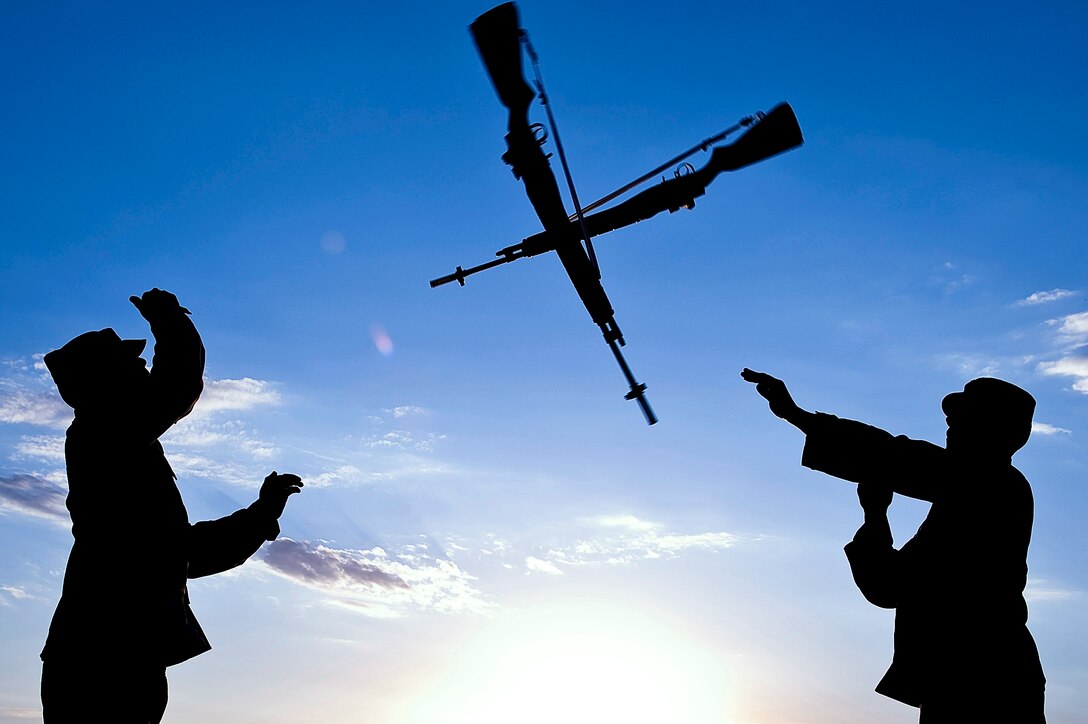 Staff Sgt. Ruben TrejoSanchez (left) and 1st Lt. Erik Ruiz practice an over-the-head rifle toss Oct. 3 at Ellsworth Air Force Base, S.D.  They are members of the Ellsworth AFB Honor Guard Drill Team. (U.S. Air Force photo/Senior Airman Marc I. Lane)
