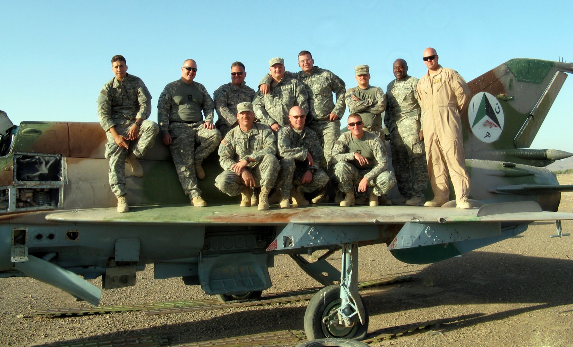 Master Sgt. Aaron Kigar (right, in desert flight suit), air liaison officer for Afghanistan Regional Security Integration Command -West at Camp Stone in Heart, Afghanistan, poses for a photo opportunity with the Army logistics support team. Sergeant Kigar is deployed to Afghanistan, and his responsibilities include manifesting and moving people and cargo by convoy to Herat Airfield in order to supply all Forward Operating Bases in Western Afghanistan. (Courtesy photo)