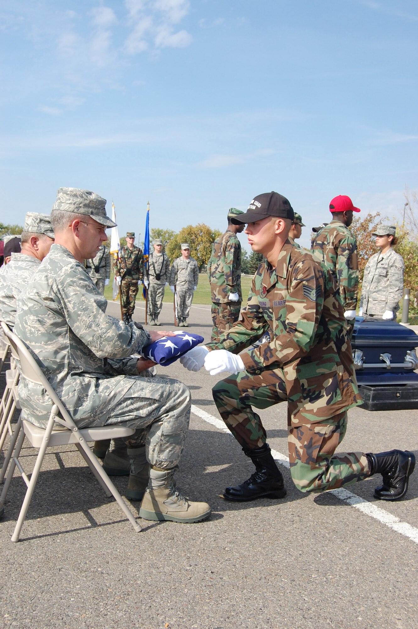 Staff Sgt. Neil Young, 341st Missile Maintenance Squadron and Honor Guard trainer, presents the flag to Col. Michael Fortney, 341st Missile Wing commander, during a graduation ceremony at the Medal of Honor Park Oct. 3. The graduation ceremony was for 18 new members of the Honor Guard who just completed a week-long training from Sept. 29 to Oct. 3. The training showed the new members how to conduct a full honors military funeral, among other Honor Guard techniques. (U.S. Air Force photo/Senior Airman Emerald Ralston)