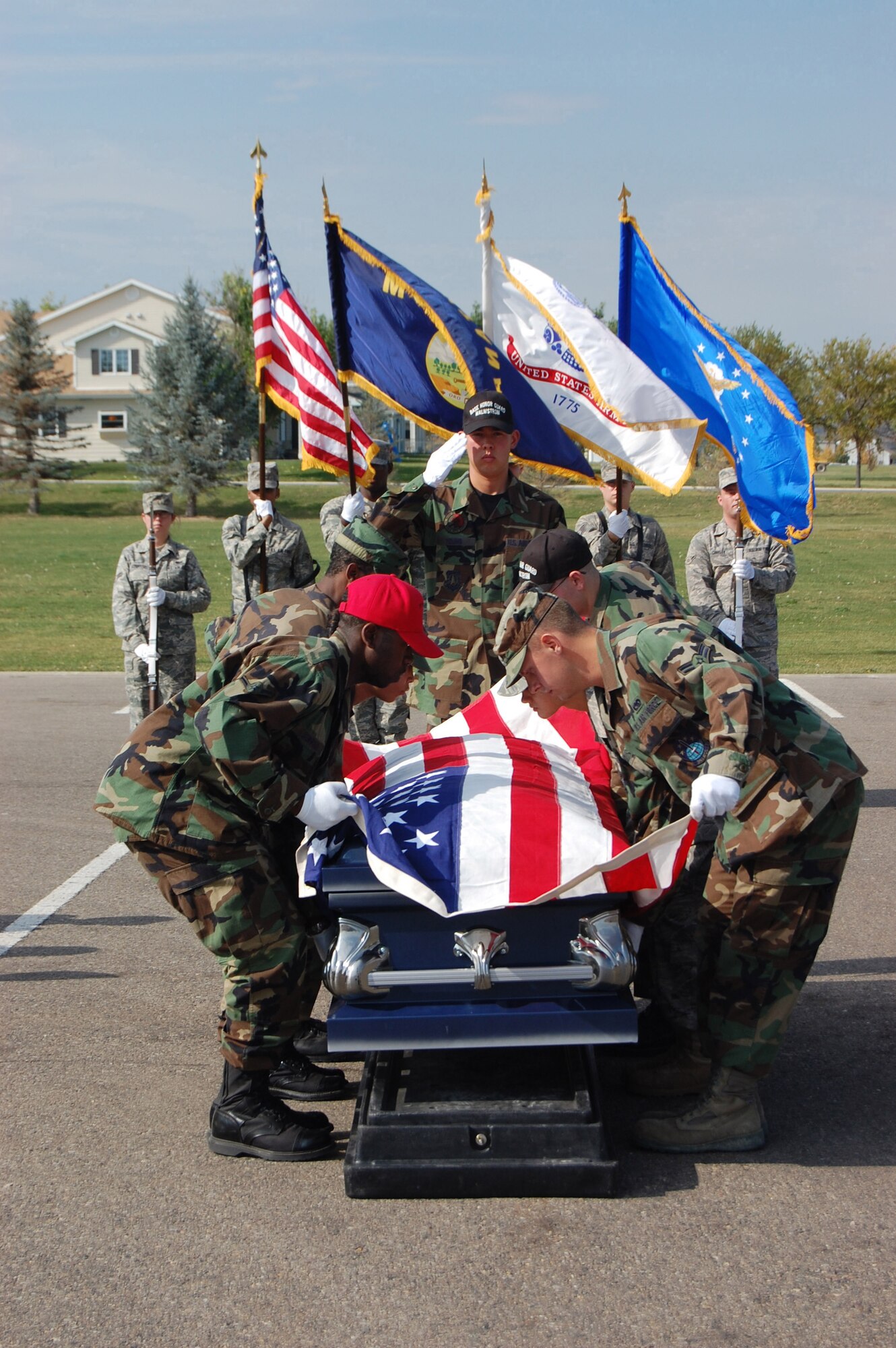 Staff Sgt. Neil Young, 341st Missile Maintenance Squadron and Honor Guard trainer, salutes as new members of the Honor Guard prepare to fold the flag after situating the casket during a mock funeral at Medal of Honor Park Oct. 3. The funeral was held in conjunction with an Honor Guard graduation for 18 new members. (U.S. Air Force photo/Senior Airman Emerald Ralston)