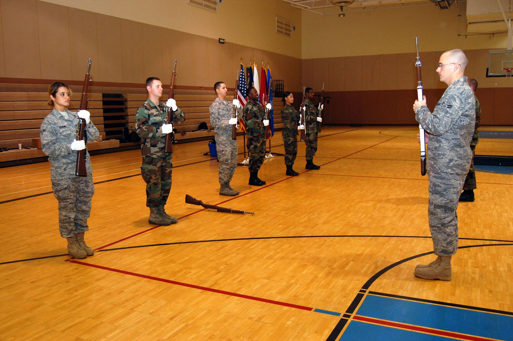 An Honor Guard trainer teaches new members the position of 'port arms' during a week-long training for 18 new members of the Honor Guard in the lower gym Oct. 2. (U.S. Air Force photo/Senior Airman Emerald Ralston)