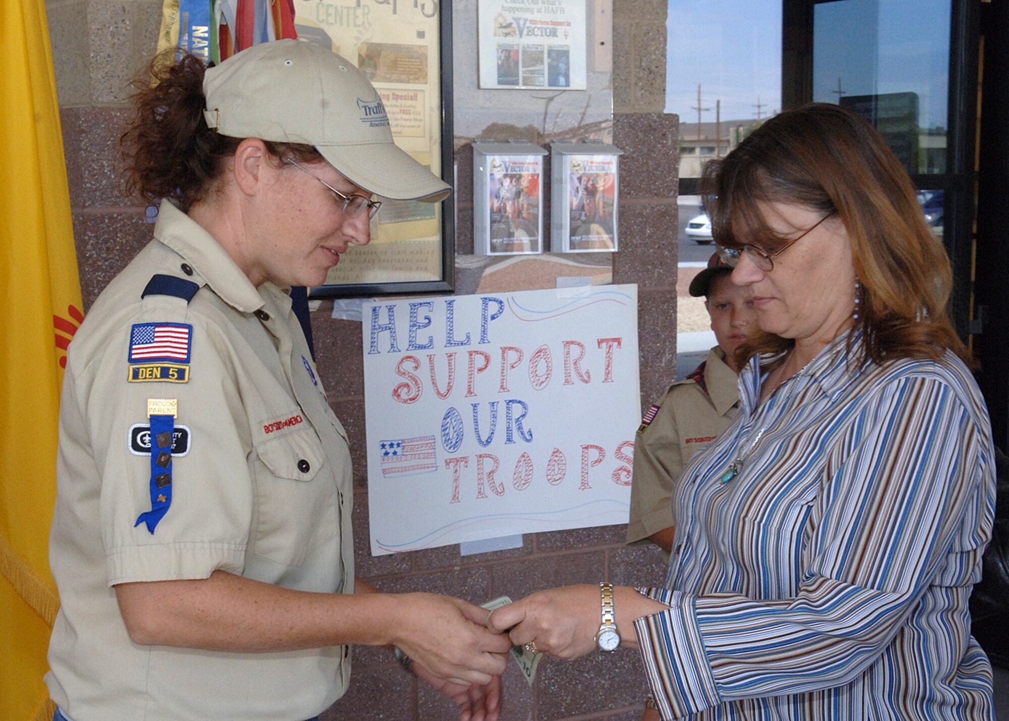 Mrs. Jennifer Byrnes, Cub Scout Pack 124 leader, accepts a donation for the Operation Wounded Warrior fund from Mrs. Louise Weber, September 27, at Holloman Air Force Base, N.M.  (U.S. Air Force photo / Airman 1st Class John D. Strong II)