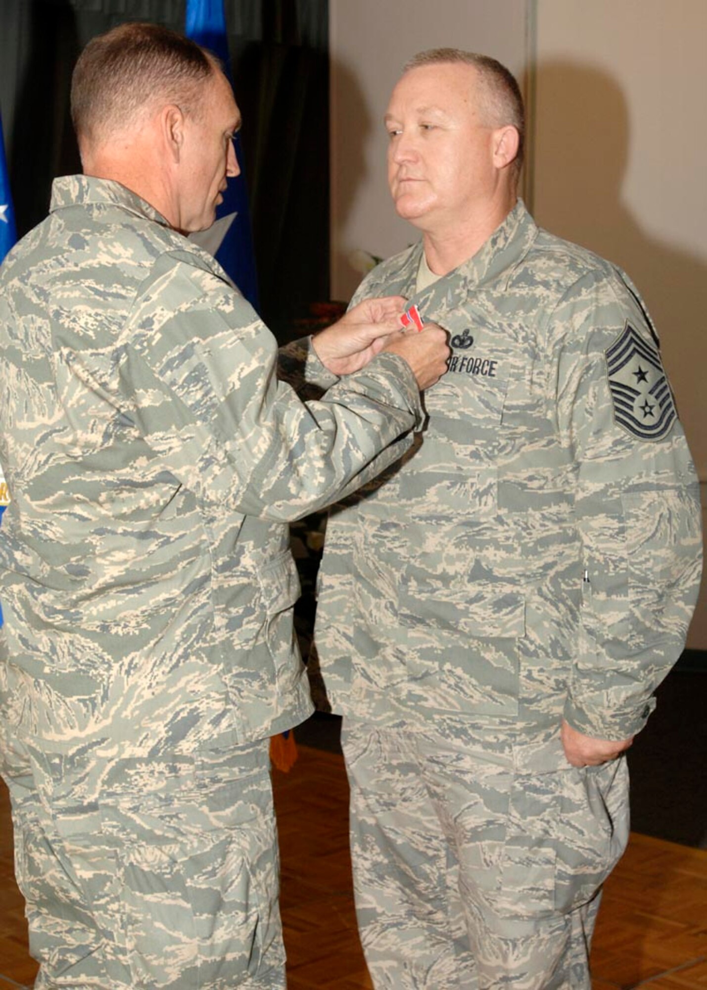 Chief Master Sgt. Paul Wheeler, Air Force District of Washington command chief, receives the Bronze Star from AFDW Commander Maj. Gen. Ralph Jodice during a ceremony at Andrews AFB, Md., Oct. 2. Chief Wheeler earned the medal for service with the 332nd Air Expeditionary Wing, engaged in combat operations at Balad Air Base, Iraq. During his time with the 332nd, the chief was the command chief to more than 26,000 Airmen located at five major air bases in Iraq. During his year in theater, the chief made more than 90 site visits across more than 10,000 miles of hostile terrain to meet with Airmen he served.  (USAF photo by Senior Airman Melissa Stonecipher)