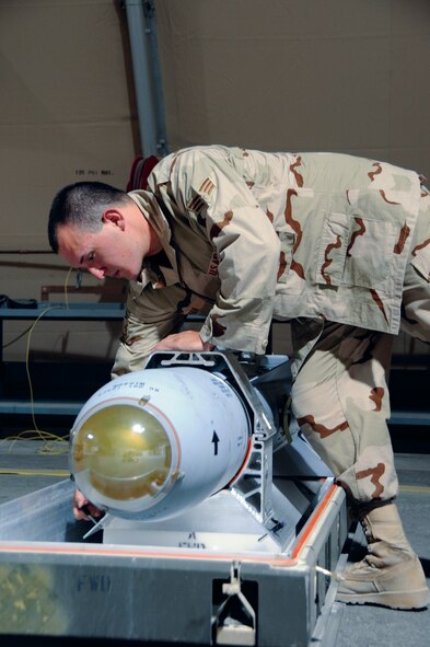 Senior Airman Fernando Mora pulls the pin on a harness holding an AGM-65 missile in Southwest Asia recently. Airman Mora removed the harness as one of the steps in a visual inspection of the missile. Airman Mora is assigned to the 379th Expeditionary Maintenance Squadron, hails from San Diego, and is deployed from Nellis Air Force Base, Nev. (U.S. Air Force photo/Tech. Sgt. Michael Boquette)