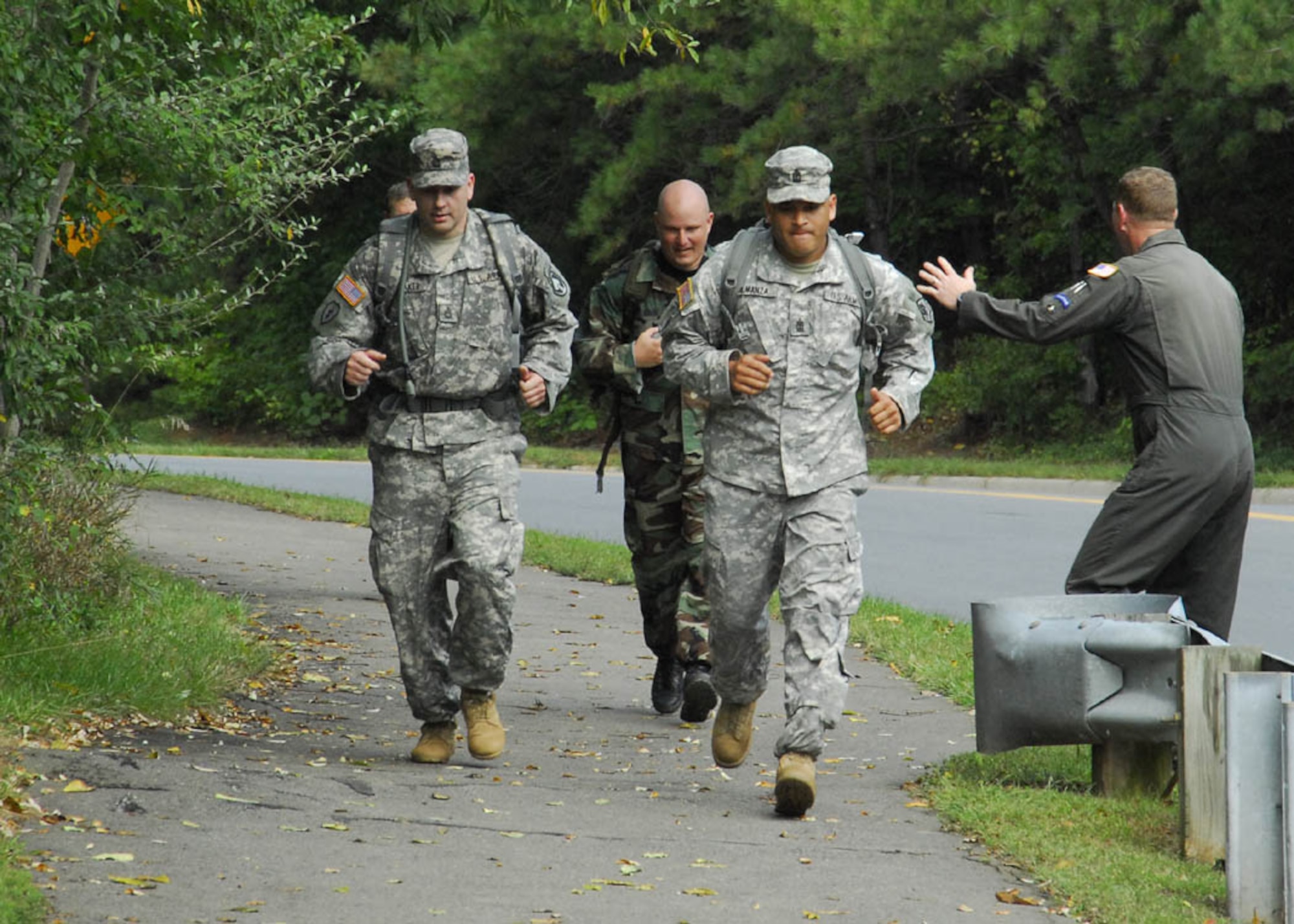 Master Sgt. Korie Gavin, 113 SFS Phoenix Raven deputy program manager (second from left), is given motivation from Sergeant Atkinson (right), at the finish line of the road march.  Sergeant Gavin came in with a run time of 3 hours and 52 minutes while attempting to obtain  German Armed Forces, Troop Duty Proficiency Badge.   (USAF photo by Tech. Sgt. Adrianne M. Wilson)