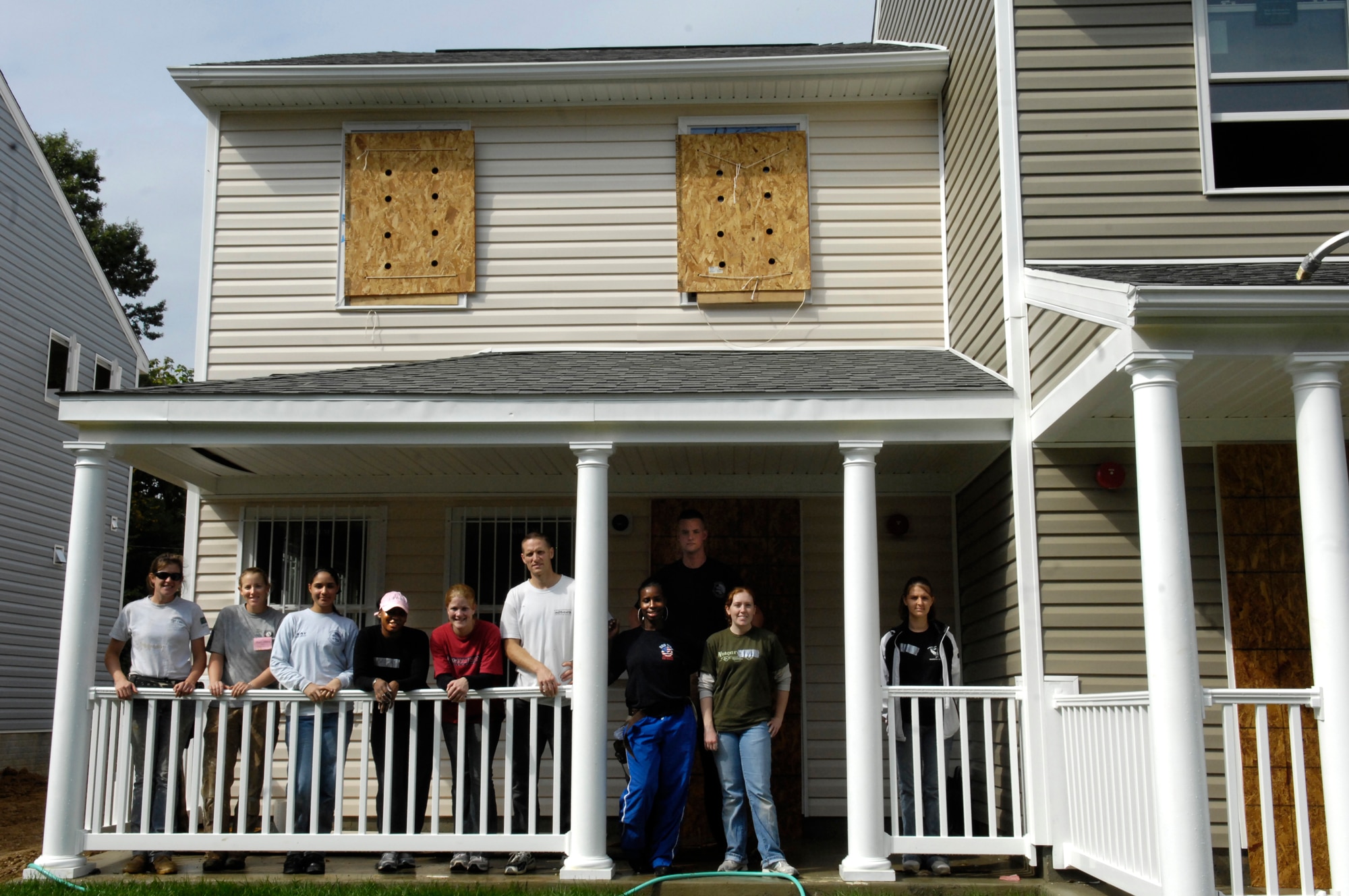 Airmen who volunteered with the Air Force District of Washington Airmen of Distinction pose for a picture with crew leaders from Habitat for Humanity in front of a nearly completed house Oct. 9 in Washington. The AFDW AOD sent eight members to help with the construction of six homes.  (U.S. Air Force photo by Senior Airman Dan DeCook)