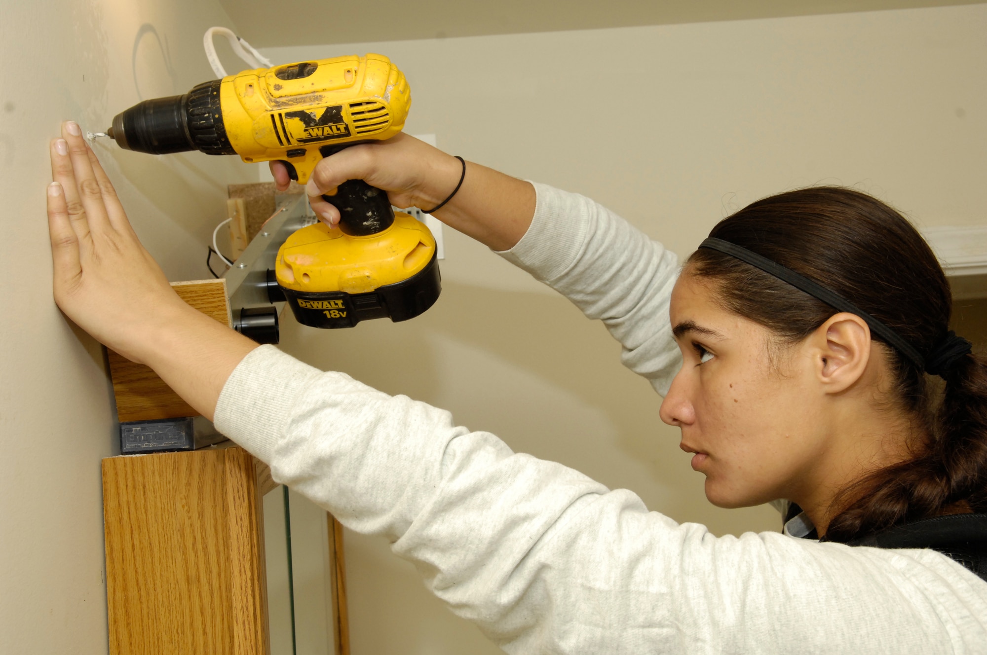 Airman 1st Class Krystie Martinez, Airmen of Distinction secretary, drills holes for a light fixture to be hung in the bathroom of a Habitat for Humanity house Oct. 9 in Washington. The AFDW AOD sent eight members to help with the construction of six homes.  (U.S. Air Force photo by Senior Airman Dan DeCook)