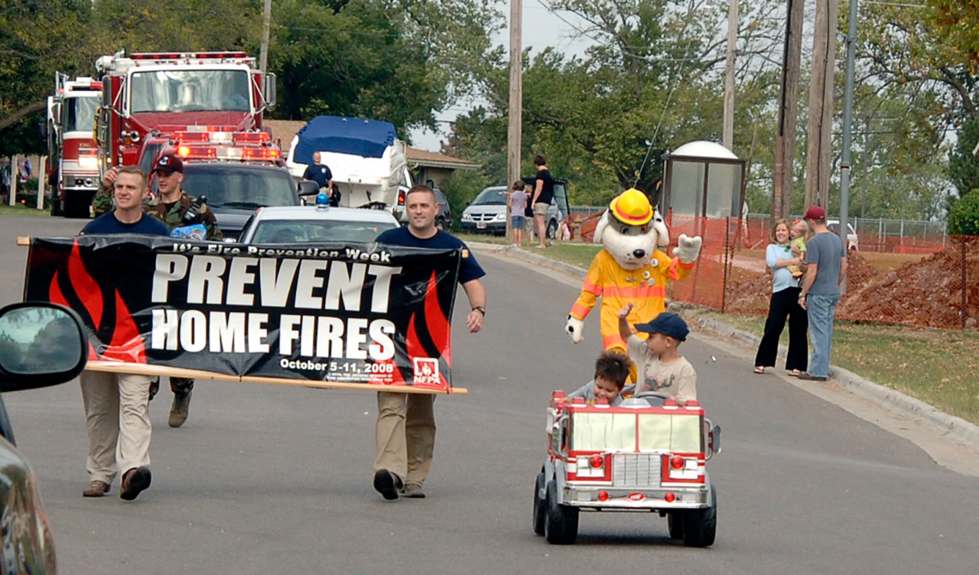MCCONNELL AIR FORCE BASE, Kan. -- McConnell's fire department members lead a procession of emergency vehicles through base housing during the Fire Prevention Extravaganza, Oct. 4. The theme of this year’s campaign, “Prevent Home Fires,” focused on preventing the leading causes of home fires – cooking, heating and electrical equipment and smoking materials. (Photo by Staff Sgt. Ronald Lafosse)