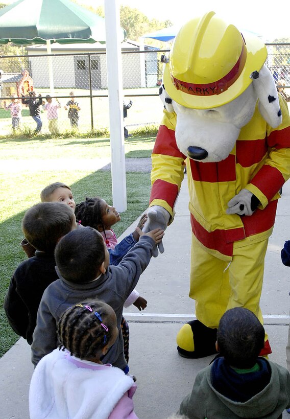 Sparky shakes hand with children during his visit to the Child Development Center on Andrews Air Force Base, Oct. 7. This week is Fire Prevention Week as declared by the President of the United States and the Wing commander.  Sparky represents a fire fighter to remind people to show support for the fire department in up holding the fire prevention theme.  (USAF photo by Senior Airman Giang Dong Nguyen)