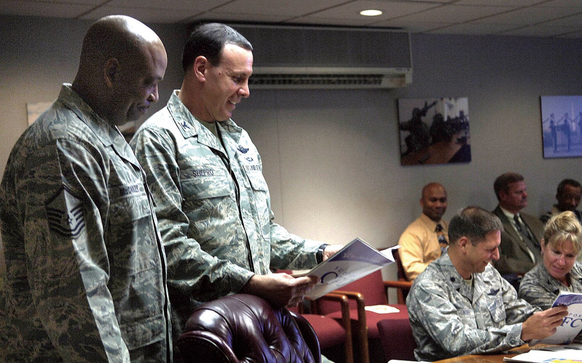 Col. Steven Shepro, 316th Wing commander, reviews the Combined Federal Campaign book with Master Sgt. Keith McCauley, wing representative for the campaign, during the weekly staff meeting Wednesday. One of this year's goals is to obtain 100 percent contact with every Andrews member. (USAF photo by Senior Airman Renae L. Kleckner)