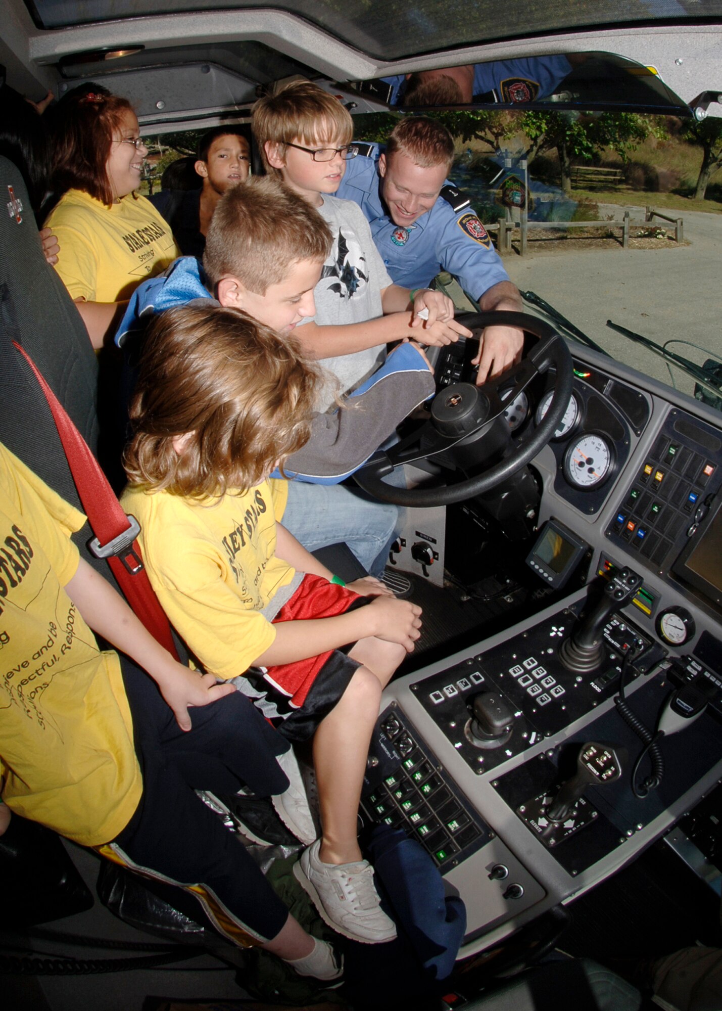 SEDGWICK COUNTY ZOO, Kan. -- Mr. Chris Muriset, 22nd Civil Engineer Squadron, explains the many P19 Striker truck capabilities to fifth-grade pupils from Cloud, Griffith, Morgan and Lewis Elementary Schools, Oct. 7.  The truck has the capability to pierce into a burning aircraft to douse water inside of it. (Photo by Airman 1st Class Maria Ruiz)