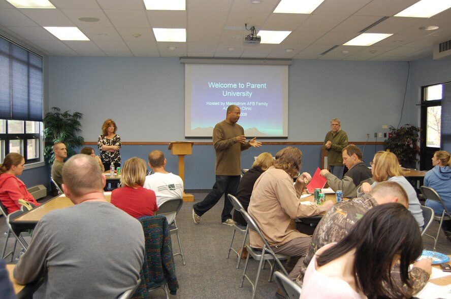 Capt. Anthony Wilson, 341st Medical Operations Squadron family advocacy officer, speaks to the crowd of people attending "Parent University" Oct. 4 at the base chapel, as Laurie Ekert, new parent support nurse, and Dennis VanHook, outreach specialist, look on. The class consisted of four briefings and was geared toward informing new parents and families about ways to manage stress, avoid violence and communicate effectively. (U.S. Air Force photo/Senior Airman Emerald Ralston)