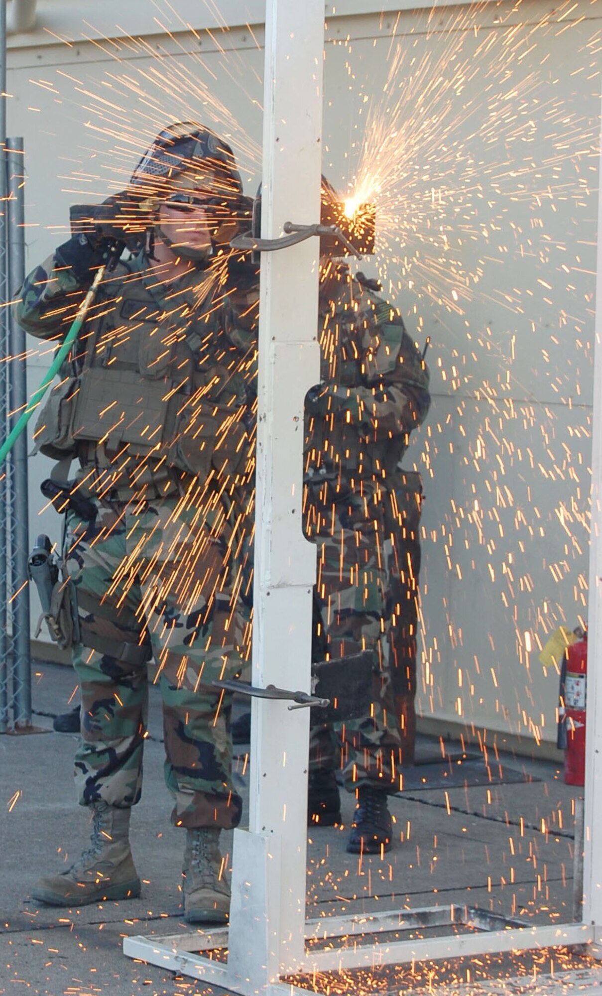 Senior Airman Jeremy Thatcher, 341st Security Forces Group Tactical Response Force member, conducts a thermal-torch cut simulating a breach on a metal door at the base’s new close-quarters battle center Sept. 30. 341st SFG personnel volunteered hundreds of hours to plan and construct the training facility .  (U.S. Air Force photo/Senior Airman Eydie Sakura)
