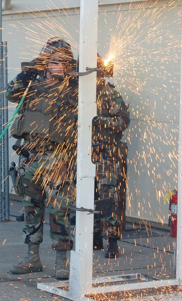 Senior Airman Jeremy Thatcher, 341st Security Forces Group Tactical Response Force member, conducts a thermal-torch cut simulating a breach on a metal door at the base’s new close-quarters battle center Sept. 30. 341st SFG personnel volunteered hundreds of hours to plan and construct the training facility .  (U.S. Air Force photo/Senior Airman Eydie Sakura)
