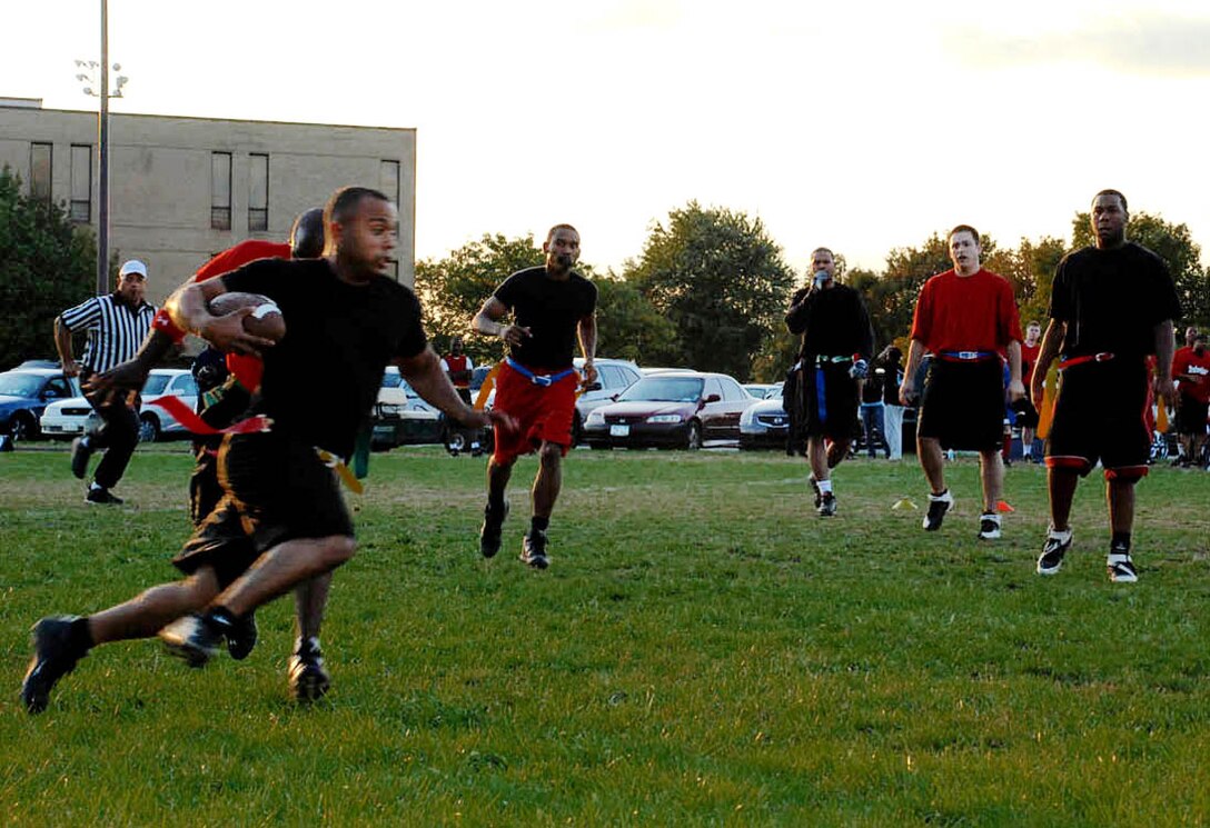 Airman 1st Class Andre Hairston, 744th Communication Squadron visual imagery intrusion detection technician, runs the ball during a play at a flag football game at the field across from the fitness center Monday.  (USAF photo by Airman Katie L. Justen)