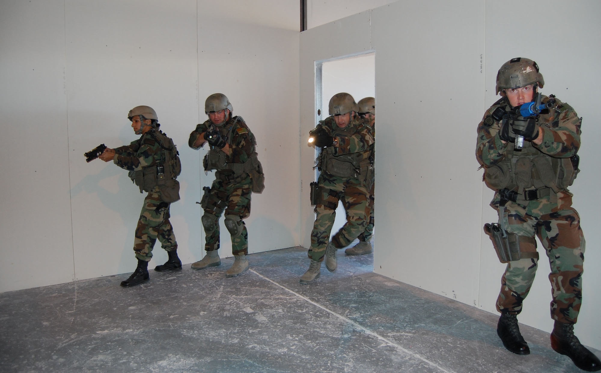 Members of the 341st Security Forces Group Tactical Response Force team make their way through the new close-quarters battle center and clear the scene Sept. 30 during a training scenario. The training facility was a self-help project planned and constructed by 341st SFG personnel who volunteered hundreds of hours of their time to build the center.  Team members include (left to right) Senior Airman Liseth Rodriguez, Staff Sgts. David Barger and Derik Morris, and Senior Airman Samuel Fullerton.  (U.S. Air Force photo/Senior Airman Eydie Sakura)
