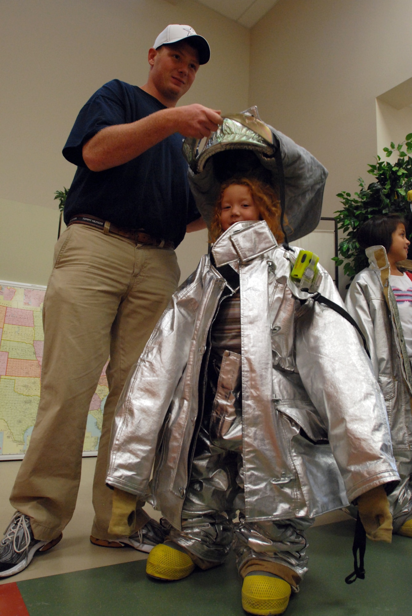 MCCONNELL AIR FORCE BASE, Kan. -- Skylar Baxley, daughter Master Sgts. James and Tarah Baxley, tries on bunker gear (fire suit) during Fire Prevention Week at the McConnell School Age Program, Oct. 6. (Photo by Airman 1st Class Jessica Lockoski)