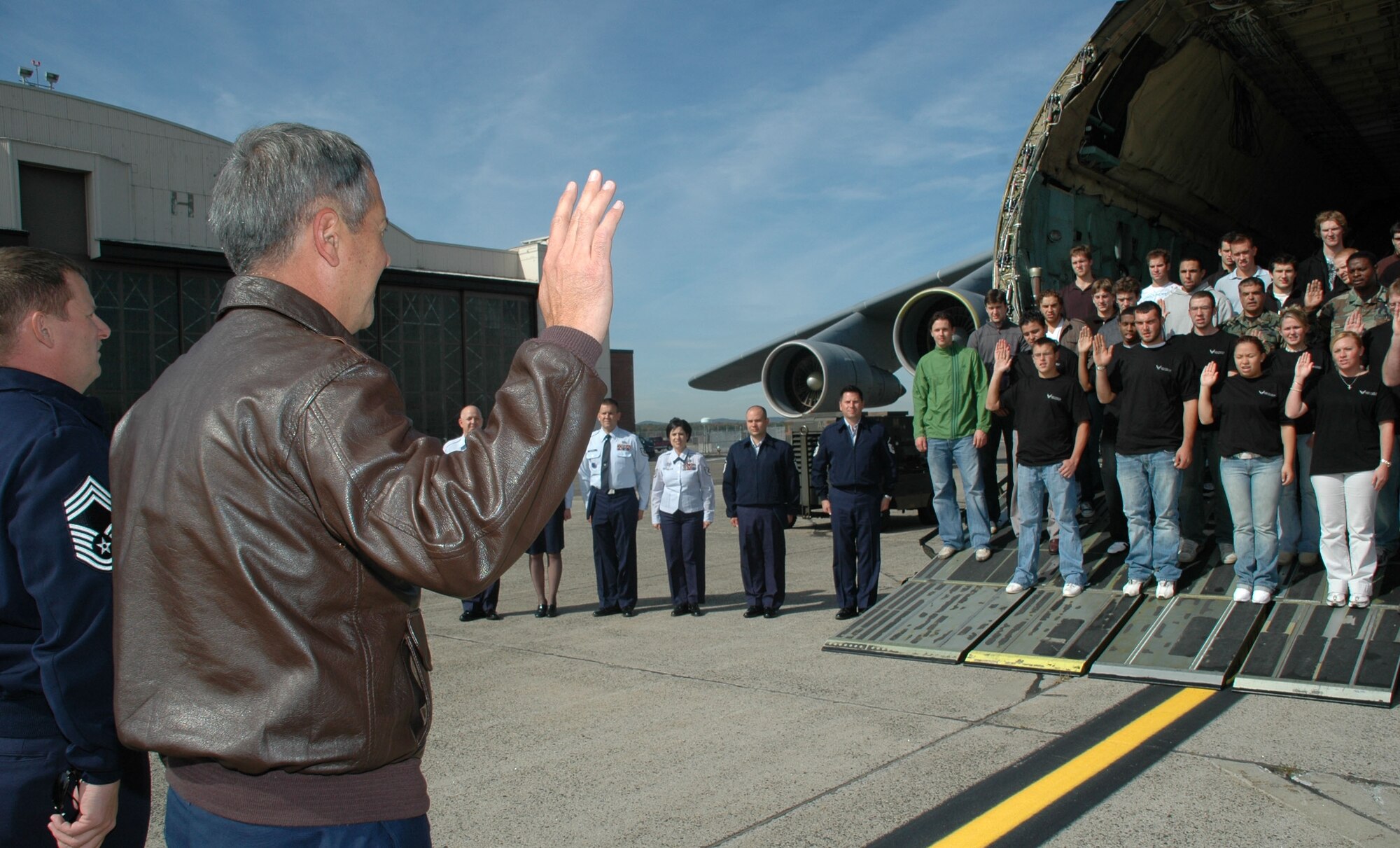 Col. Robert Swain, 439th Airlift Wing commander, leads the oath of enlistment with Chief Master Sgt. Erik Anderson, wing senior recruiter, during the mass enlistment ceremony held Oct. 8 in a Patriot Wing C-5 Galaxy. More than 20 men and women either reenlisted or enlisted as new Airmen in the Air Force Reserve. (US Air Force photo/Tech. Sgt. Andrew Biscoe)