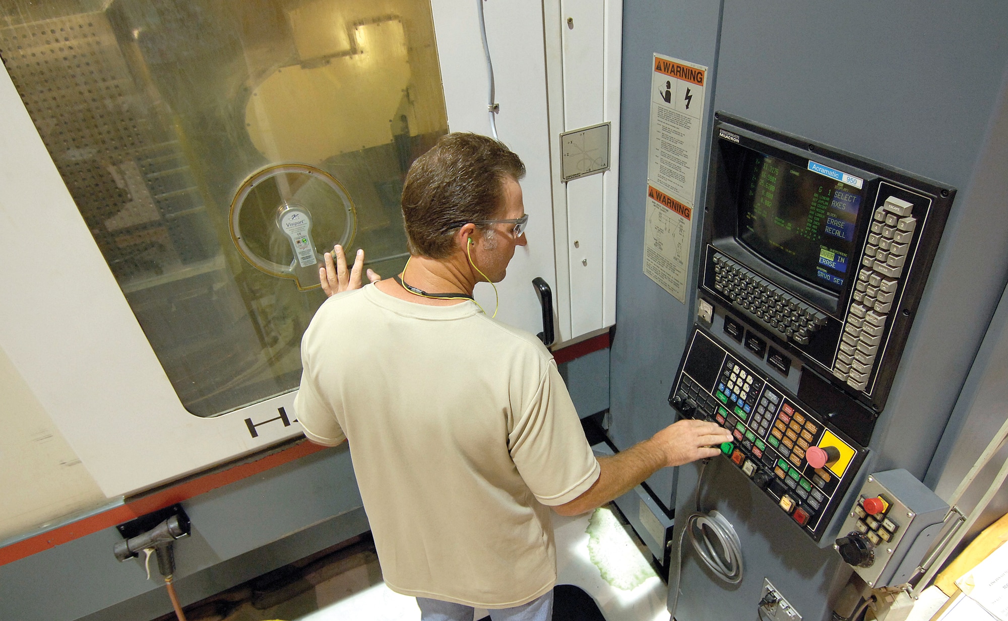 Machinist Paul Spurlock, Numerical Controlled Machining Cell, monitors a B-1 part being manufactured.  The cell runs 24 hours a day in Bldg. 3001 and Mr. Spurlock likes the night shift as it allows him more time with his family during the day.  (Air Force photo/Margo Wright)