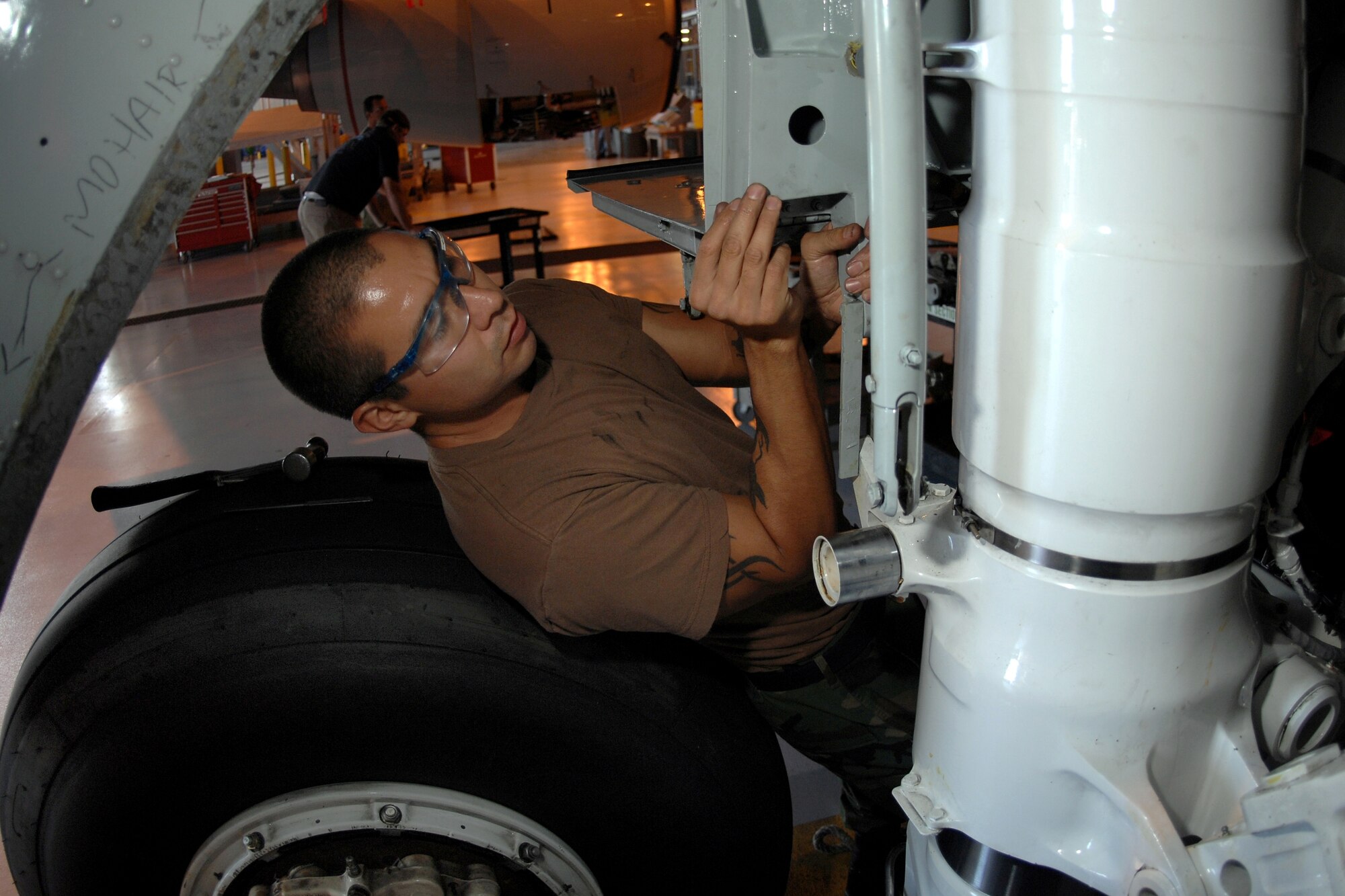 OFFUTT AIR FORCE BASE, Neb.  -- Staff Sgt. Mark Martinez, a repair reclamation craftsmen assigned to the 55th Aircraft Maintenance Squadron, installs an Oleo Strut Door onto a TC-135W pilot training aircraft here, Oct. 1. (U.S. Air Force Photo By Josh Plueger)