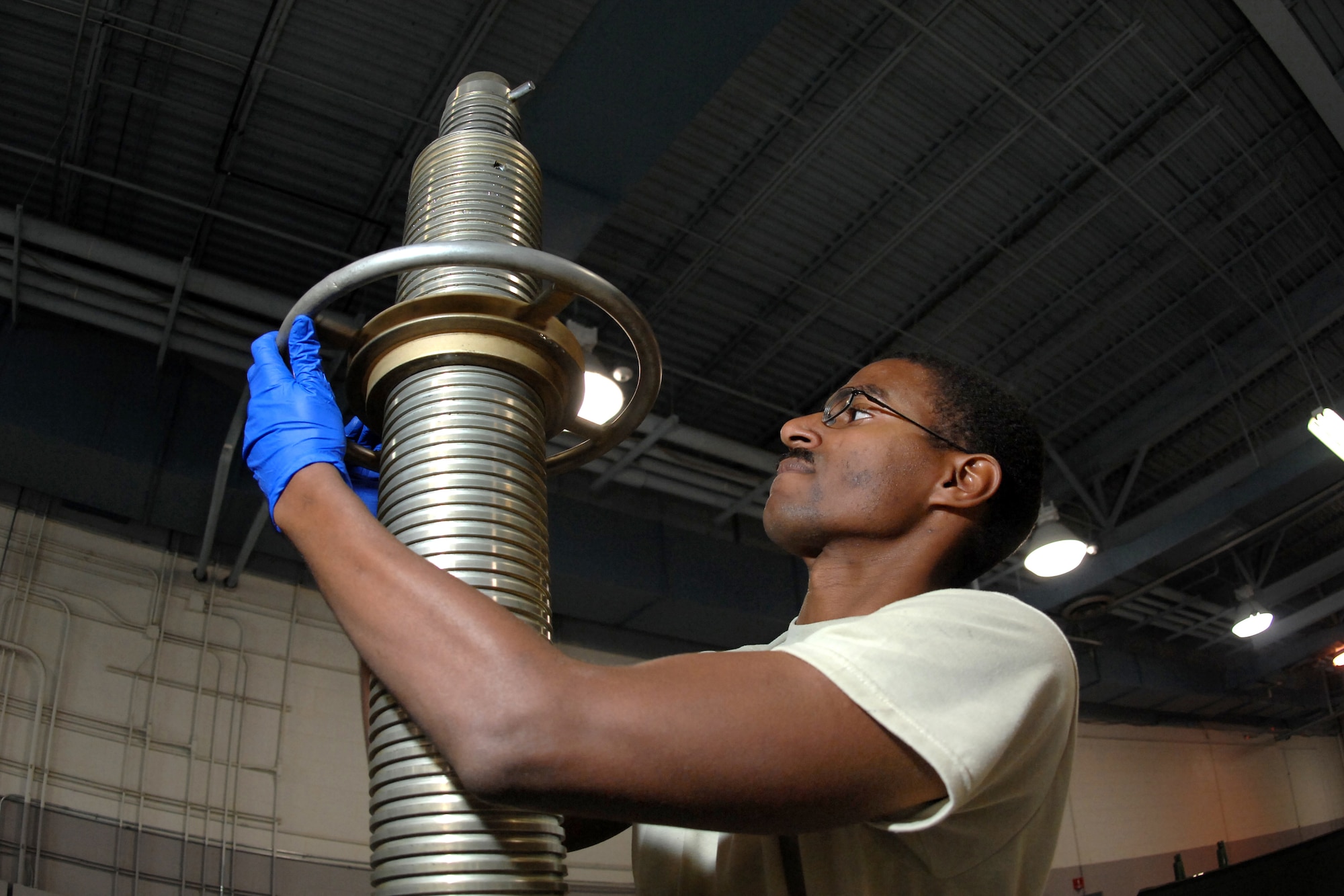 OFFUTT AIR FORCE BASE, Neb. --  Senior Airman Anton Fletcher, an aerospace ground equipment mechanic assigned to the 55th Maintenance Squadron here, inspects a 40 ton tripod jack, used on the nose end of aircraft here, Oct. 1. (U.S. Air Force Photo By Josh Plueger)