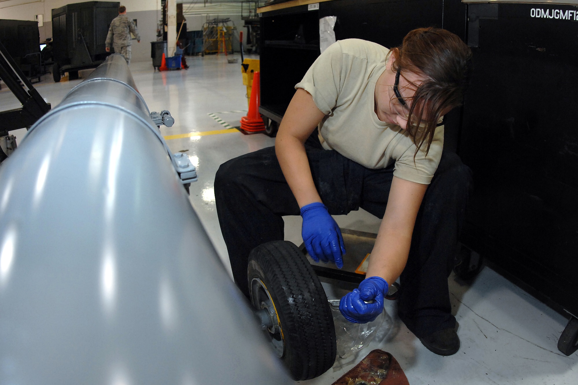 OFFUTT AIR FORCE BASE, Neb. -- Senior Airman Jacqueline Weekly, an aerospace ground equipment mechanic assigned to the 55th Maintenance Squadron, repacks wheel bearings on an RC-135 tow bar here, Oct. 1. (U.S. Air Force Photo By Josh Plueger)