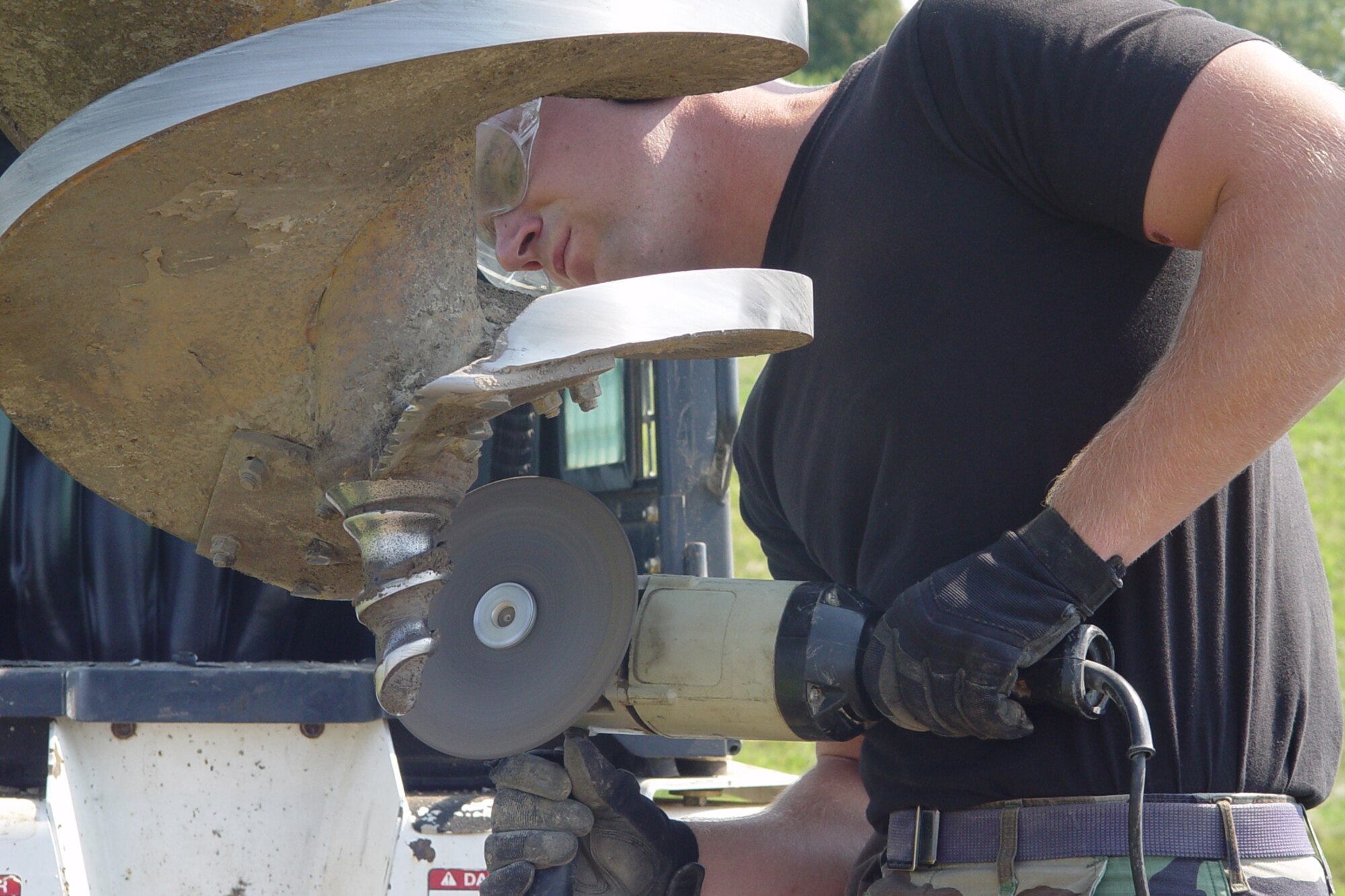 GRISSOM AIR RESERVE BASE, Ind., -- Staff Sgt. Adam Loos, a carpenter apprentice with the 434th Civil Engineers Squadron, sharpens the auger bit on a bobcat prior to setting a post used for an exercise station. CE members at Grissom have been installing fitness stations along the running track on base. (U.S. Air Force photo/Senior Master Sgt. Chuck GIll)
