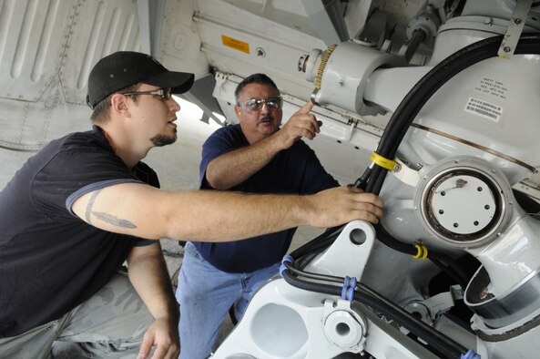 Jason Clements and Bill Hurst, aircraft mechanics, check the main landing gear of the first C-17 to undergo maintenance under the multi-skill system. U. S. Air Force photo by Sue Sapp