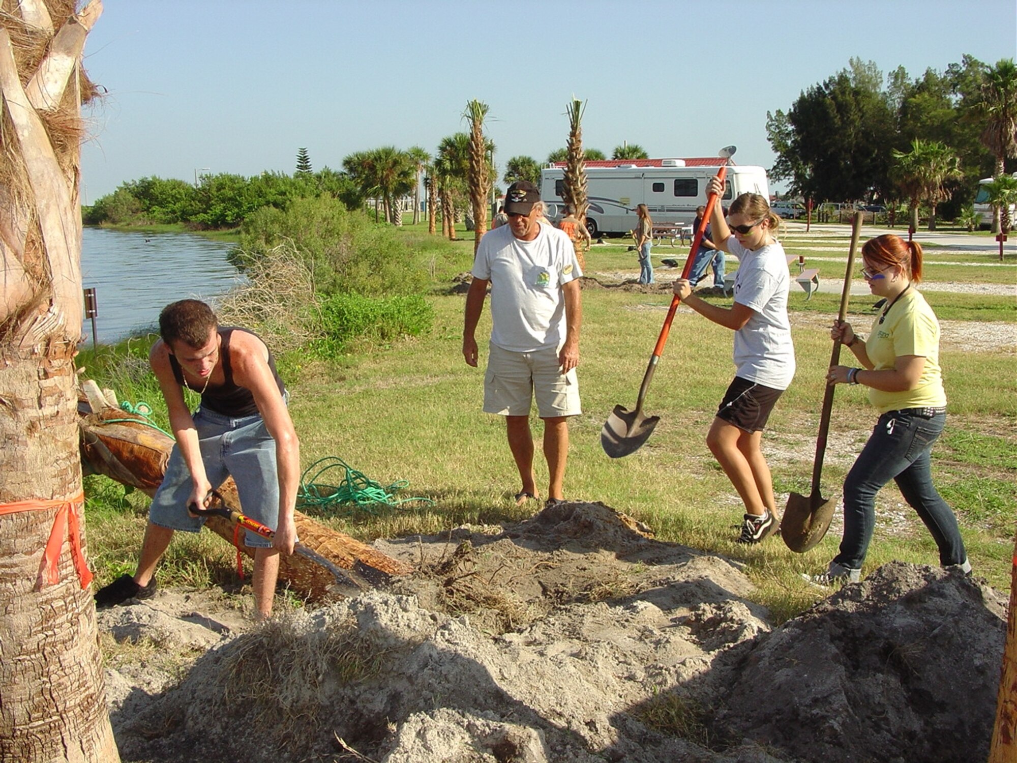 (left to right) Satellite High School JROTC members A.J. Stagner, Sydney Welzel and Jennifer Augustyniak dig a hole for a new tree at the Patrick campground September 27. The gentleman in the cap is Camp Host Jimmy Sullivan. (U.S. Air Force photo by Dale Hawkins)
