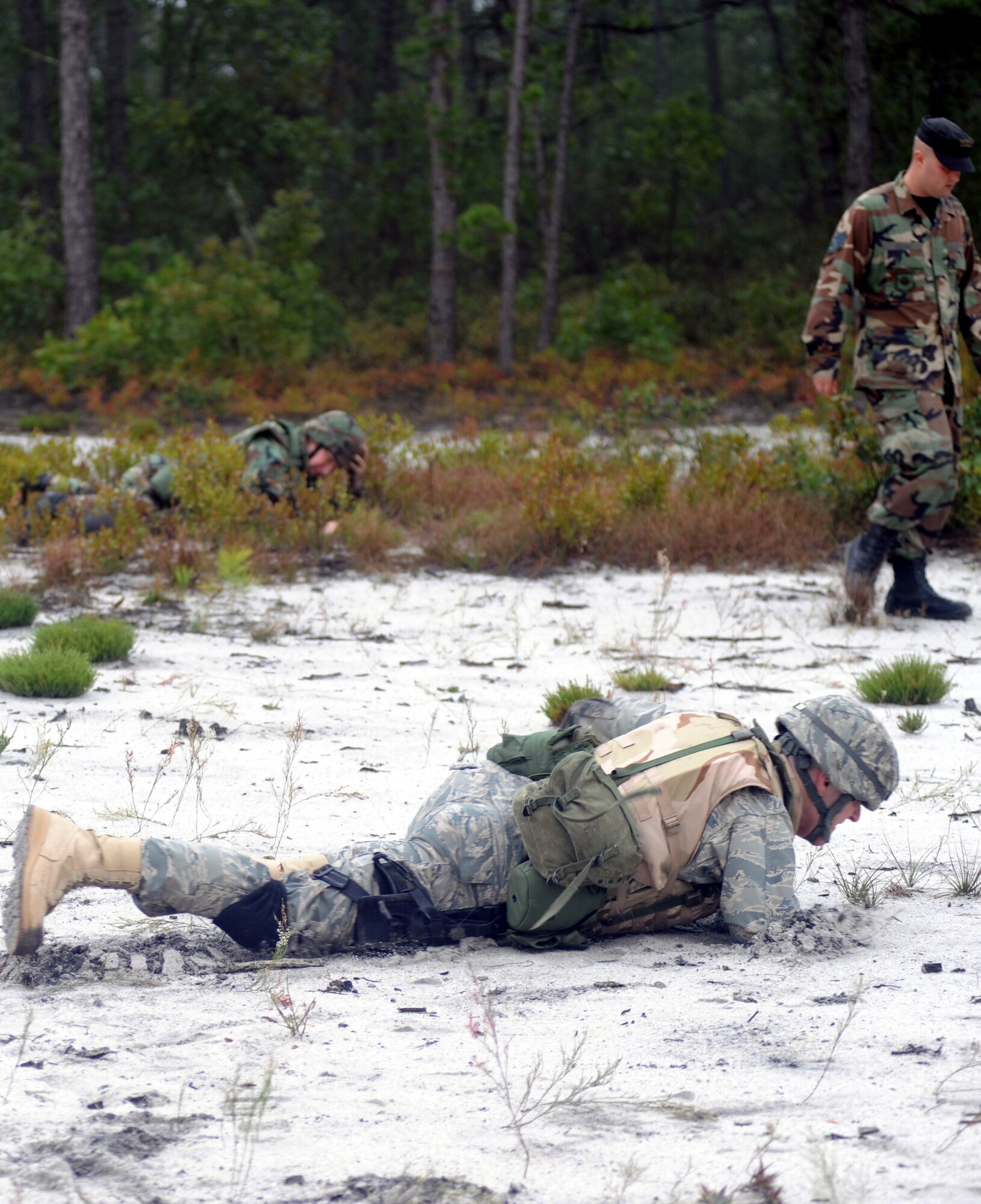 Students partcipating in functional-specific training for the Air Force legal career field learn "low-crawl" techniques during a class on a Fort Dix, N.J., range Oct. 1, 2008.  The functional-specific training for the students of the Air Force legal career field focuses on contingency skills basics, rules of use of force, rules of engagement and expeditionary basics for legal Airmen on deployment. The training is held for three days prior to them attending the Advanced Contingency Skills Training Course taught by the U.S. Air Force Expeditionary Center's 421st Combat Training Squadron on Fort Dix.  (U.S. Air Force Photo/Staff Sgt. Nathan Bevier)