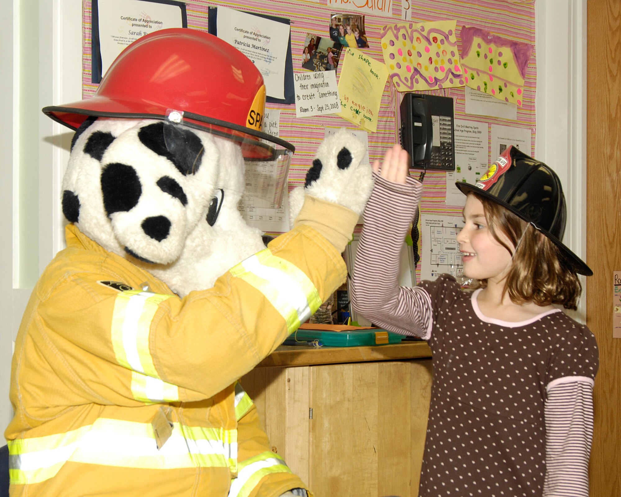 HANSCOM AFB, Mass. – Megan McKenna gives a high-five to Sparky the Fire Dog during Fire Prevention Week activities at the Hanscom Primary School on Oct. 8. The Hanscom Fire Department conducted a number of educational activities and events across the base throughout the week to spread the message about the importance of fire safety. (U.S. Air Force photo by Linda LaBonte Britt)