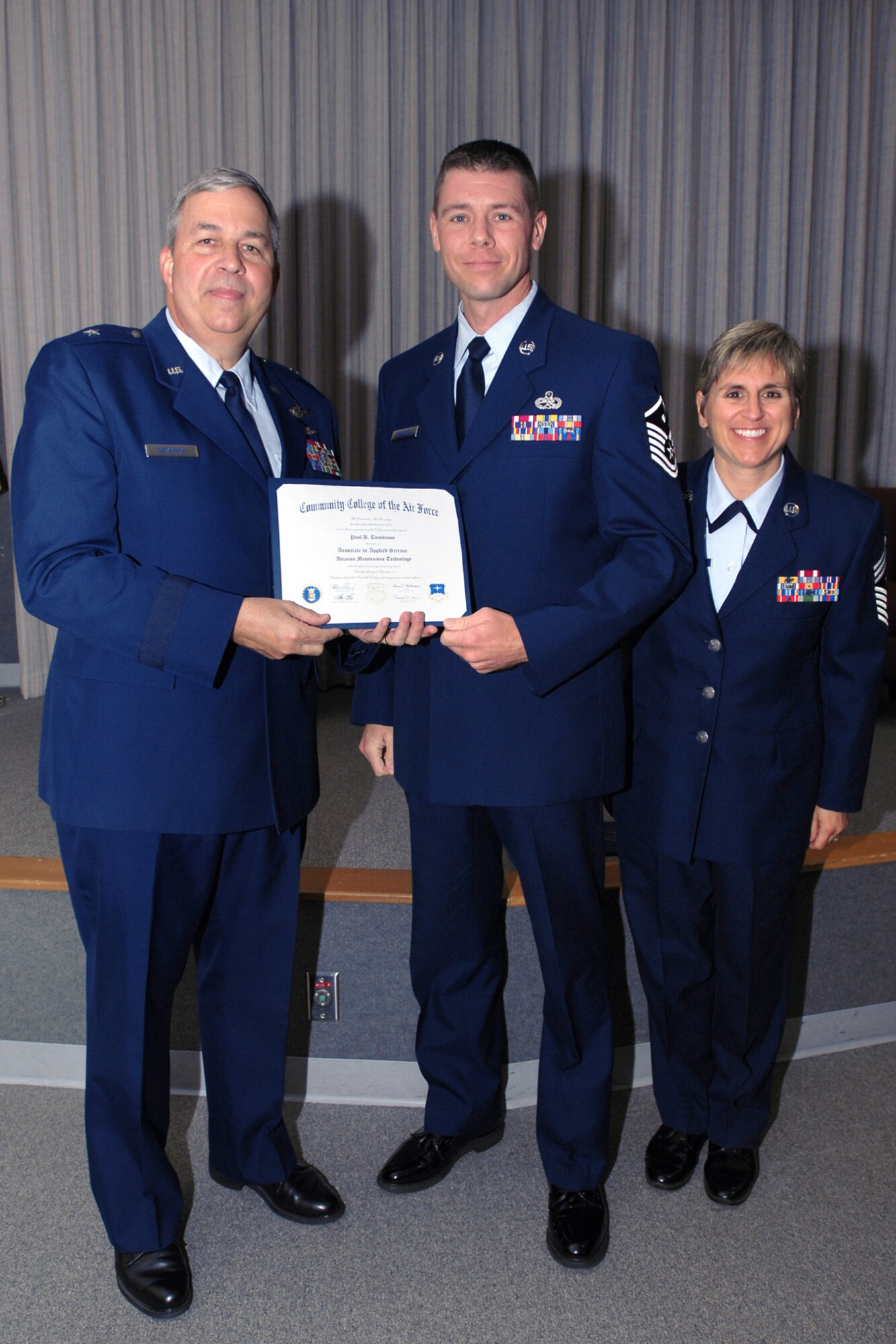 GRISSOM AIR RESERVE BASE, Ind. -- Master Sgt. Paul Tomlinson (center), 434th Services Flight first sergeant, poses for a photo during a Community College of the Air Force graduation ceremony held here in October. Pictured alongside Sergeant Tomlinson are Brig. Gen. Dean Despinoy, 434th Air Refueling Wing commander, and Chief Master Sergeant Peri Rogowski, 434th ARW command chief.  Sergeant Tomlinson received his CCAF degree in aviation maintenance technology. (U.S. Air Force photo/Staff Sgt. Mark Orders-Woempner)