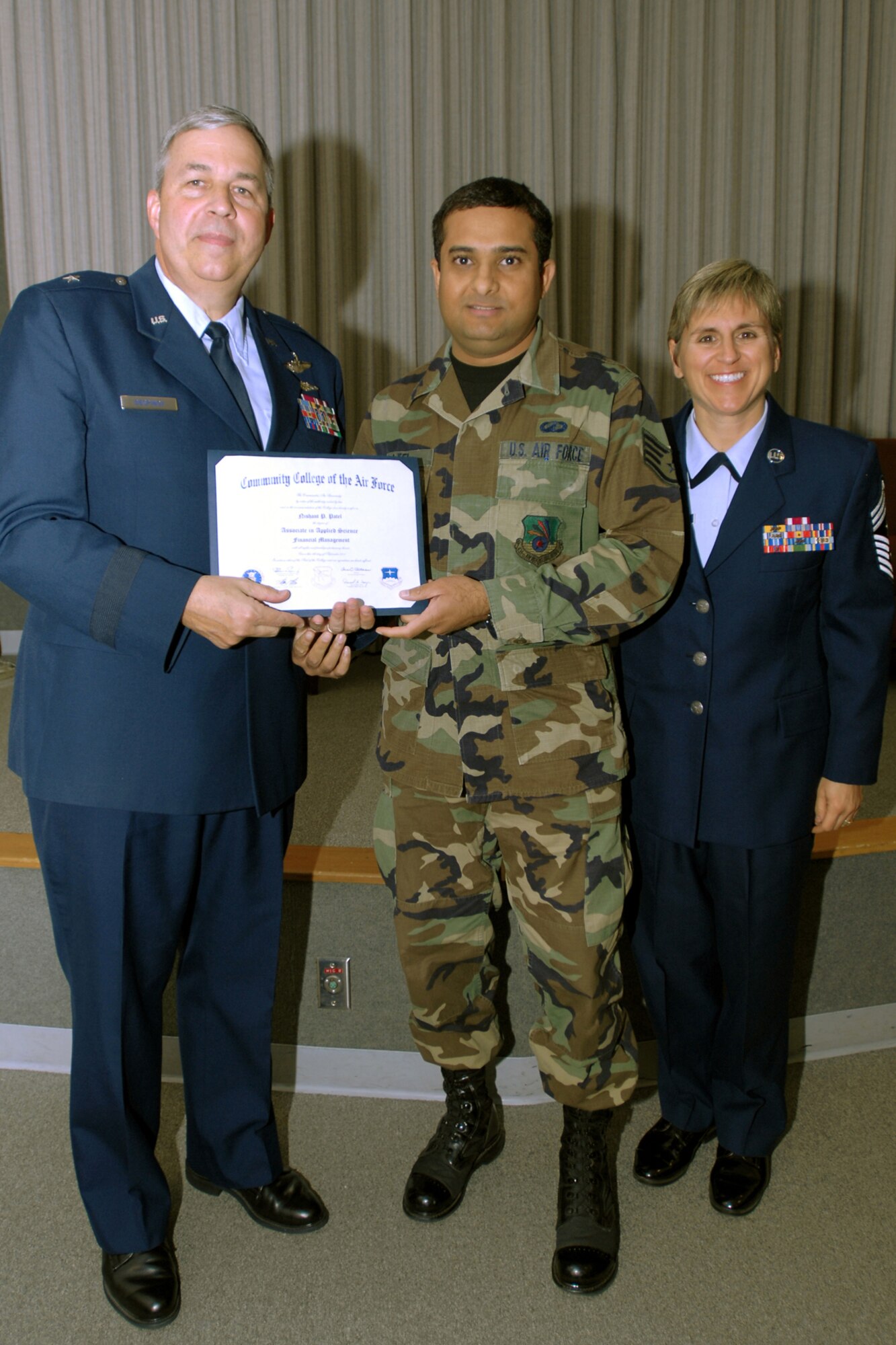 GRISSOM AIR RESERVE BASE, Ind., -- Staff Sgt. Nishant Patel, 434th Communications Squadron secure computer maintenance apprentice, is presented with his diploma during a recent Community College of the Air Force graduation ceremony.  Presenting the dipolma is Brig. Gen. Dean Despinoy, 434th Air Refueling Wing Commander (left), and Chief Master Sgt. Peri Rogowski.  (U.S. Air Force photo/Staff Sgt. Mark Orders-Woempner)