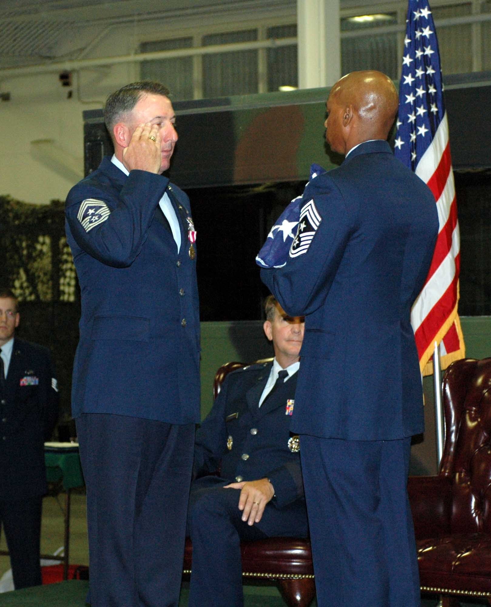 Chief Master Sgt. Bruce Blodgett receives the flag from Chief Master Sgt. Michael Williams, 60th Air Mobility Wing command chief, during his retirement ceremony Oct. 3. Chief Blodgett retired as the 15th Expeditionary Mobility Task Force command chief after serving more than 27 years in the Air Force. Chief Blodgett arrived at Travis in September 2007 from Dover Air Force Base, Del., where he served as 436th Airlift Wing command chief. (U.S. Air Force Airman 1st Class Kristen Rohrer)