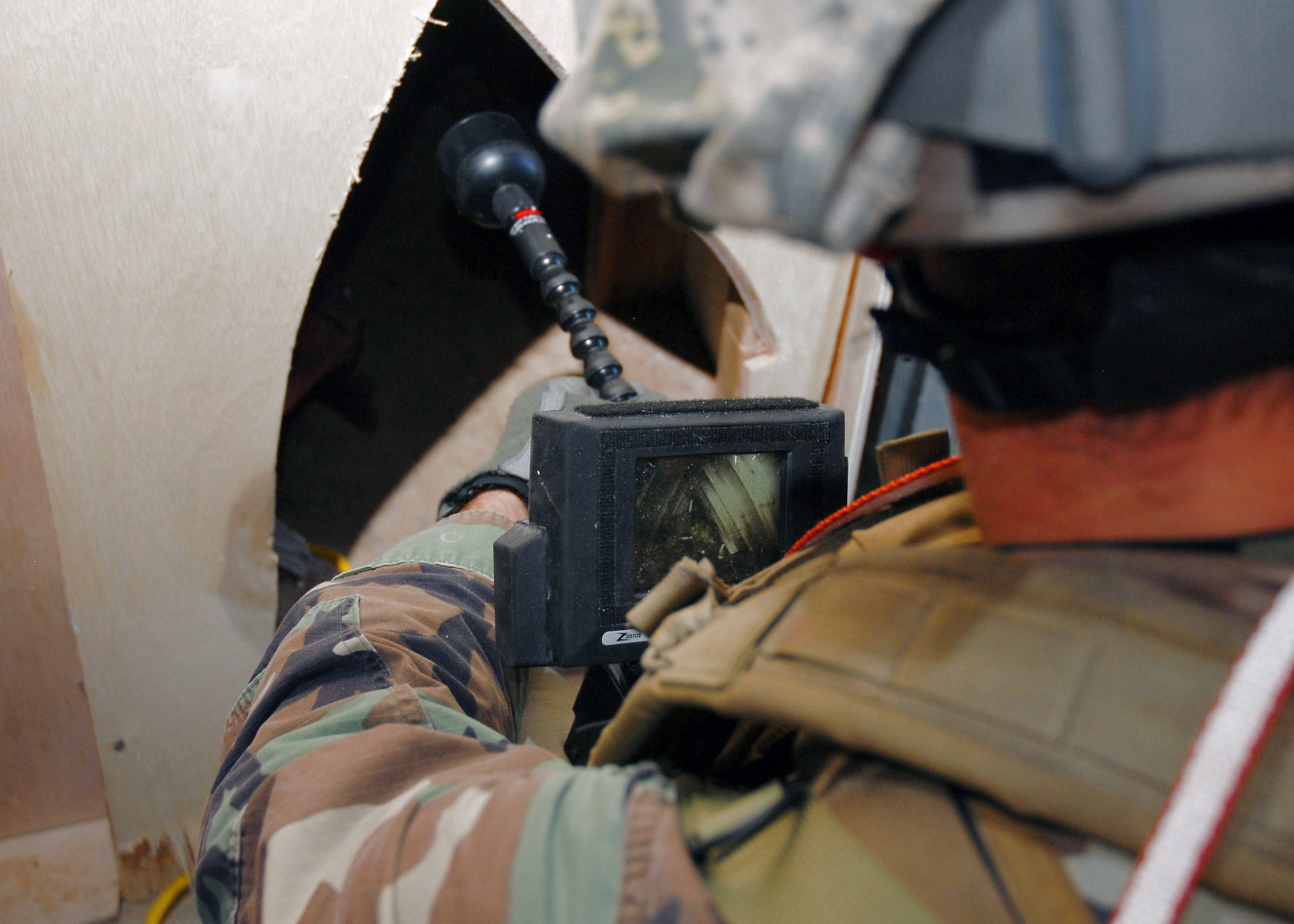 Capt. Nicholas Shimkus of the 31st Rescue Squadron at Kadena Air Base, Japan, uses a video camera to search inside a narrow space before entering it during confined-space training Oct. 3. The training prepares the rescue Airmen to execute operations in confined spaces and collapsed structures.  (U.S. Air Force photo/Airman 1st Class Amanda Grabiec)