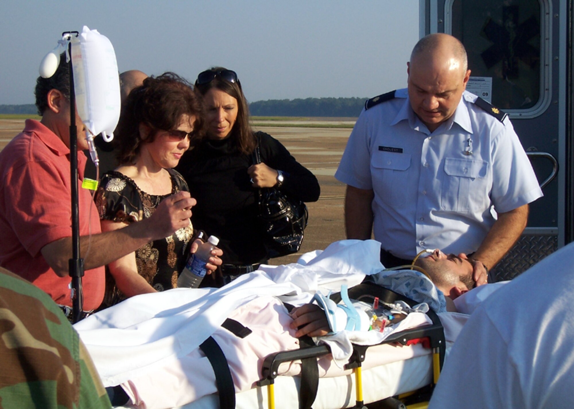 Chaplain (Major) Alan Chouest leads 2nd Lt. David Hernandez, 14th Operational Support Squadron, and his family in a moment of prayer before being transferred to an aircraft for medical evacuation to Wilford Hall Medical Center, Lackland AFB, Texas, Oct. 6. Lieutenant Hernandez was injured last weekend in a boating accident on the Tennessee-Tombigbee Waterway. (Courtesy Photo)
