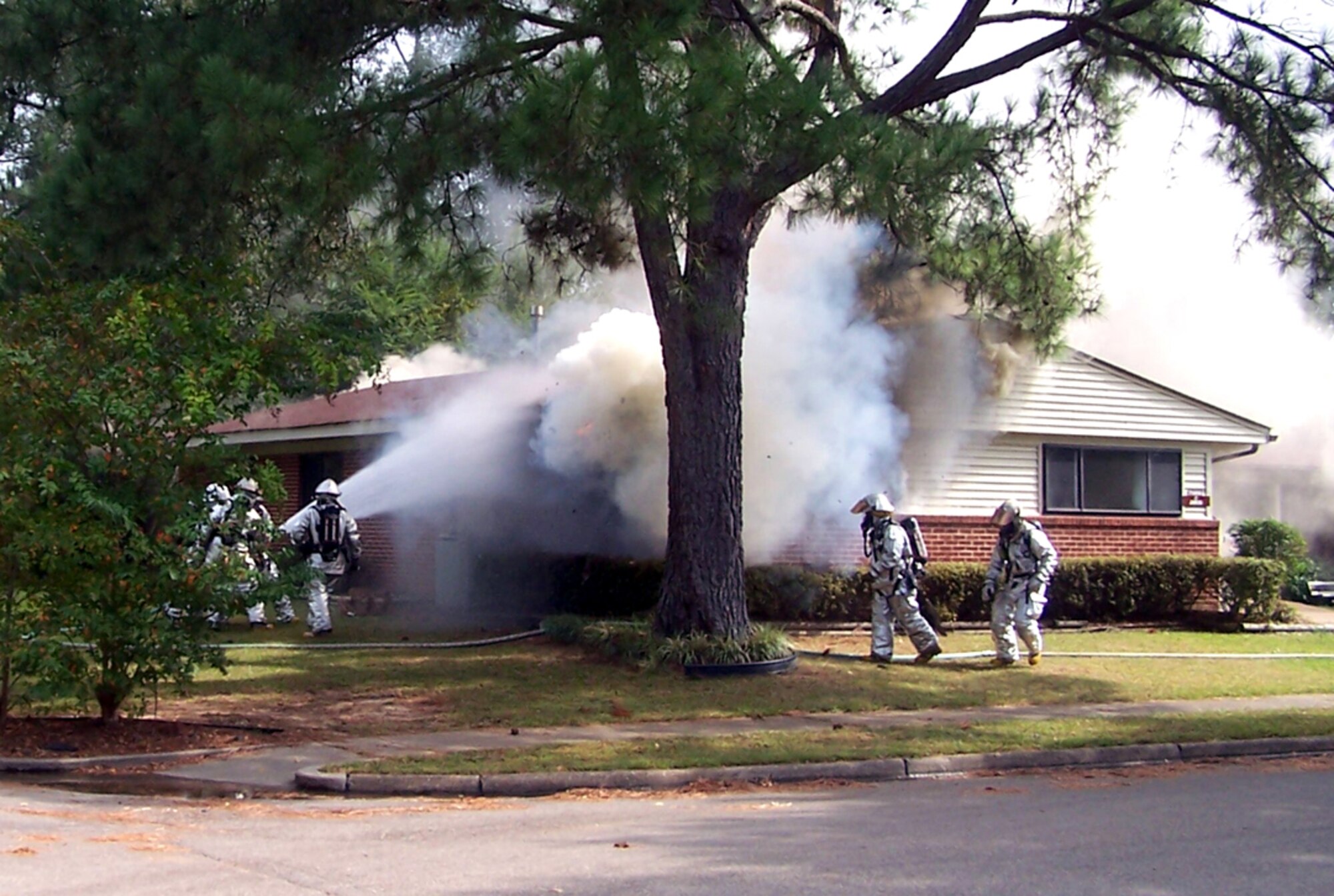 Columbus AFB firefighters work to extinguish a house fire in base housing which took place Oct. 11, 2005. The fire was started by a four-year-old child who lit a bedspread on fire while playing with a lighter. The estimated loss totaled approximately $121,000. (U.S. Air Force photo)