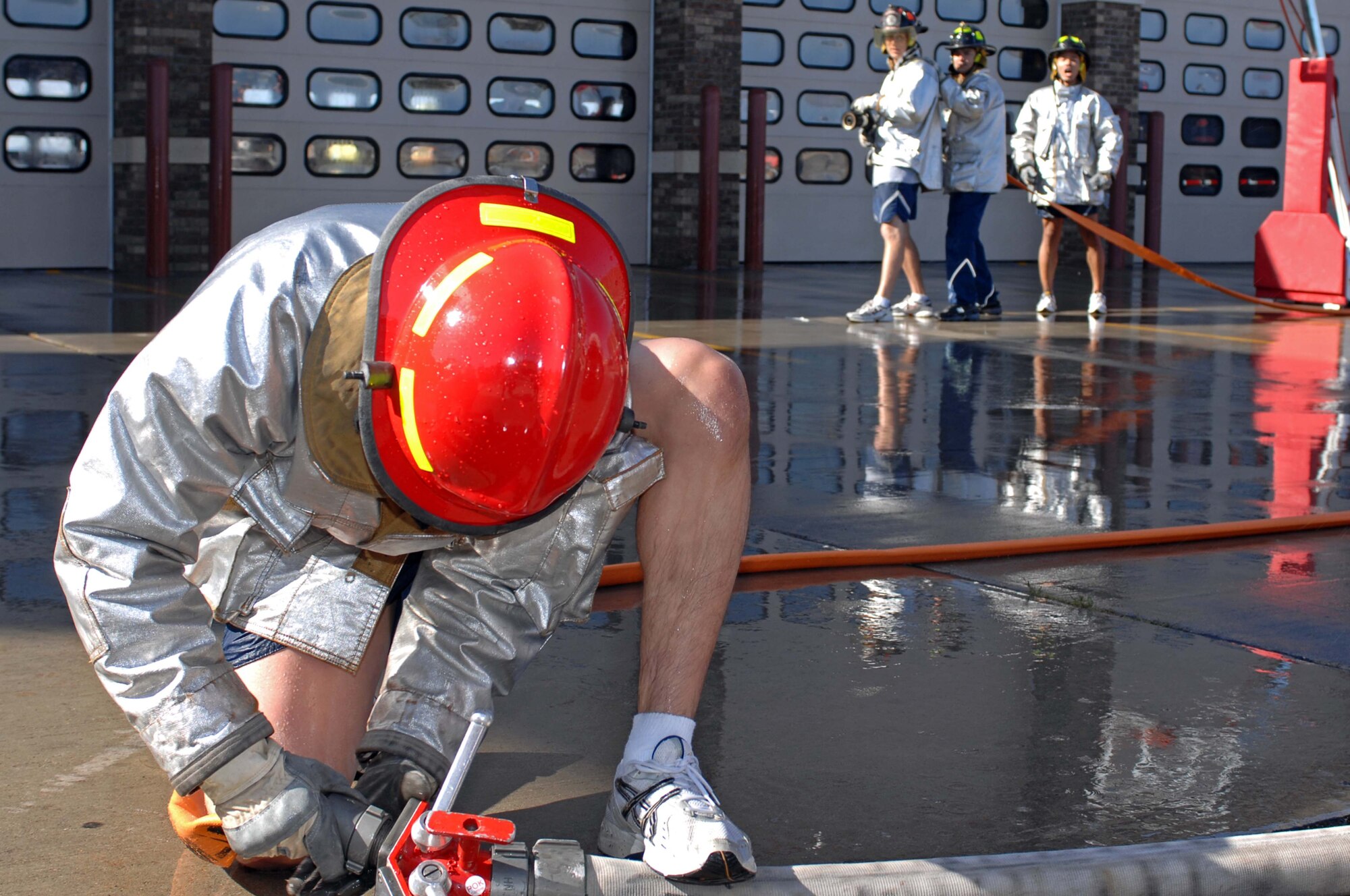 Airman 1st Class Christopher Moreno, 28th Civil Engineer Squadron electrician, couples the hose lines to provide water during a water barrel-spraying contest as part of the Firefighter Challenge. Each team had a member charge the hose, providing water to spray the barrels. (U.S. Air Force photo by Airman Corey Hook)