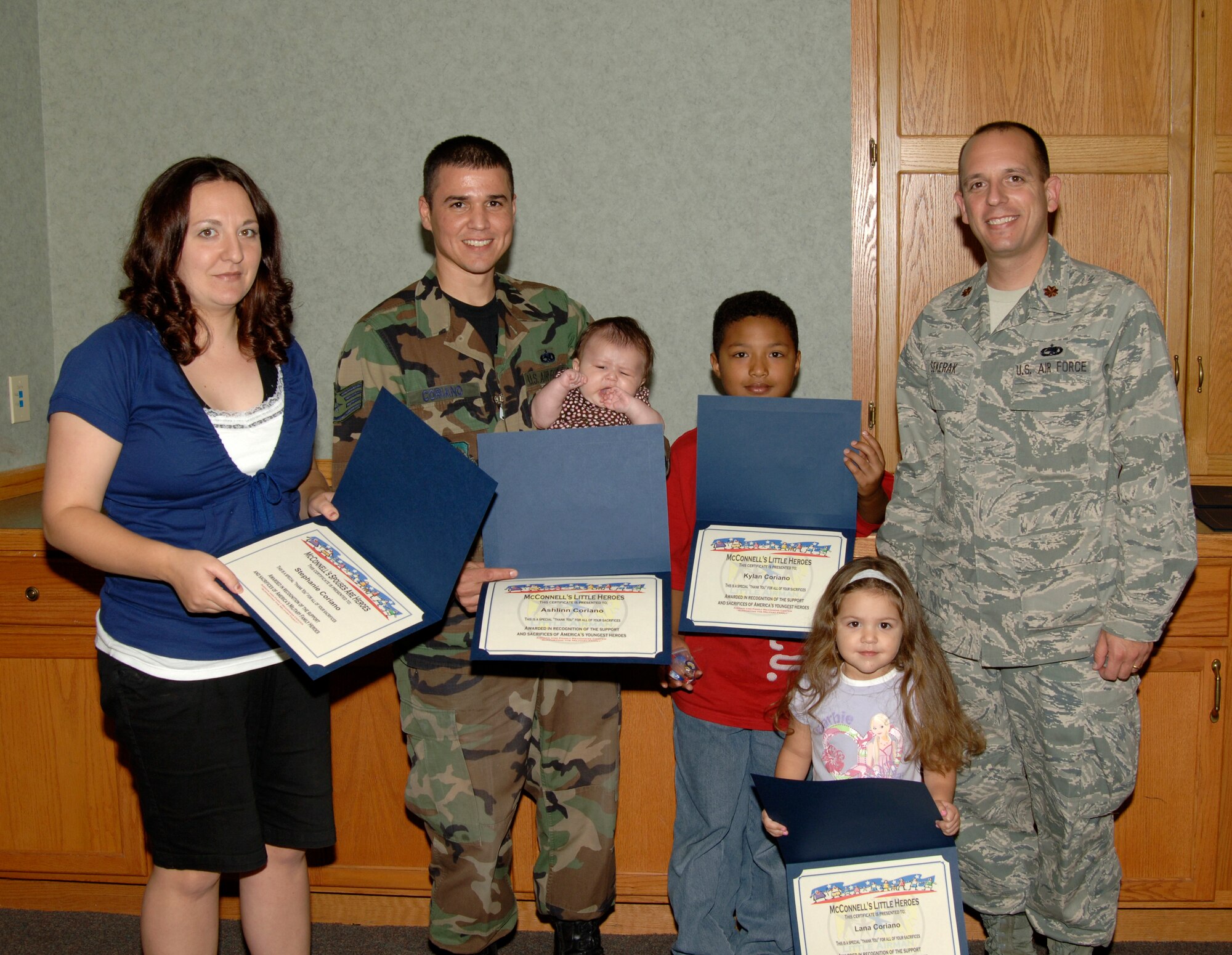 MCCONNELL AIR FORCE BASE, Kan. -- Staff Sgt. Braulio Coriano, 22nd Maintenance Operations Squadron, poses with his wife, Stephanie, Ashlinn, three months, Kylan, nine years and Lana, three years as they receive certificates of appreciation in the 22nd Air Refueling Wing base chapel, Oct. 2. The Coriano family received certificates from the 22nd Maintenance Squadron during the “little heroes” ceremony for their support during Sergeant Coriano’s recent deployment. (Photo by Senior Airman Laura Suttles)