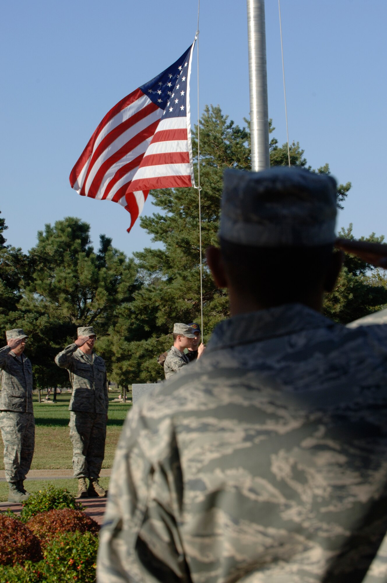 MCCONNELL AIR FORCE BASE, Kan. -- 22nd Maintenance Operations Squadron Airmen salute our nations flag during a retreat ceremony outside the wing headquarters building, Oct. 2. Most squadrons and groups conduct a squadron retreat in honor of the members who have served and are currently serving within the military. (Photo by Senior Airman Laura Suttles)
