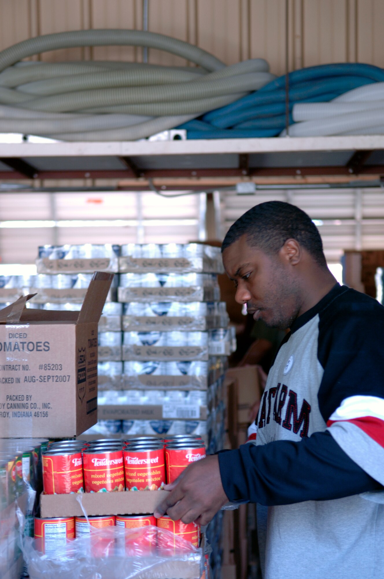GRAND FORKS AIR FORCE BASE, N.D. - Senior Airman Chavis Wright, 319th Communications Squadron, prepares cans of food at the Red River Valley Community Action. The food will be packaged into boxes and bags and delivered to more than 600 elderly citizens who are unable to get their own food. (U.S. Air Force photo/Staff Sgt. J. Paul Croxon)