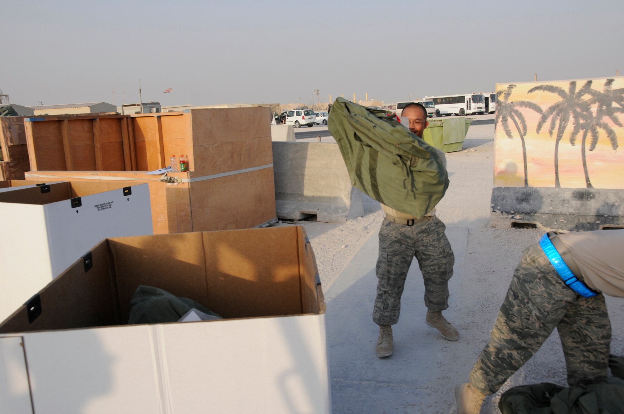 Airman 1st Class Charlton Ysip, 379th Expeditionary Logistics Readiness Squadron, tosses a C-Bag into a temporary box October 8, 2008.  The C-bag contains sealed chemical gear, including overgarment suits, gloves, boots, gas mask canisters and M-291 decontamination kits.  The bags are returned items from Airmen rotating back to home stations after completing their deployments.  The bags are sorted by size and stored here at an undisclosed air base in Southwest Asia.  Airman Ysip is from Pittsburg, Calif., and deployed from Luke Air Force Base, Ariz., in support of Operations Iraqi and Enduring Freedom and Joint Task Force-Horn of Africa.  (U.S. Air Force photo by Tech. Sgt. Michael Boquette/Released)