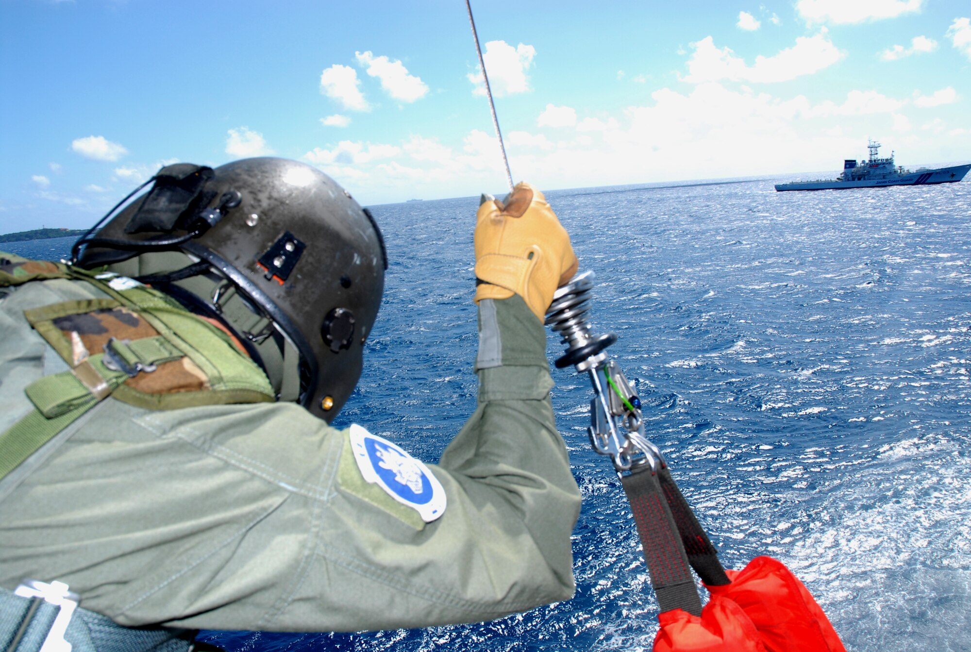 Master Sgt. Ernest Garcia, a flight engineer assigned to the 33rd Rescue Squadron, waits for a signal from the Pararescue Airman in the water to bring the downed pilot onboard an HH-60 during a crisis management exercise off the coast of Okinawa Oct. 8 2008. Members of the 18th Wing and Japanese Coast Guard rehearsed response procedures for a simulated over the water aircraft accident. (U.S. Air Force photo/Staff Sgt. Chrissy Best)
