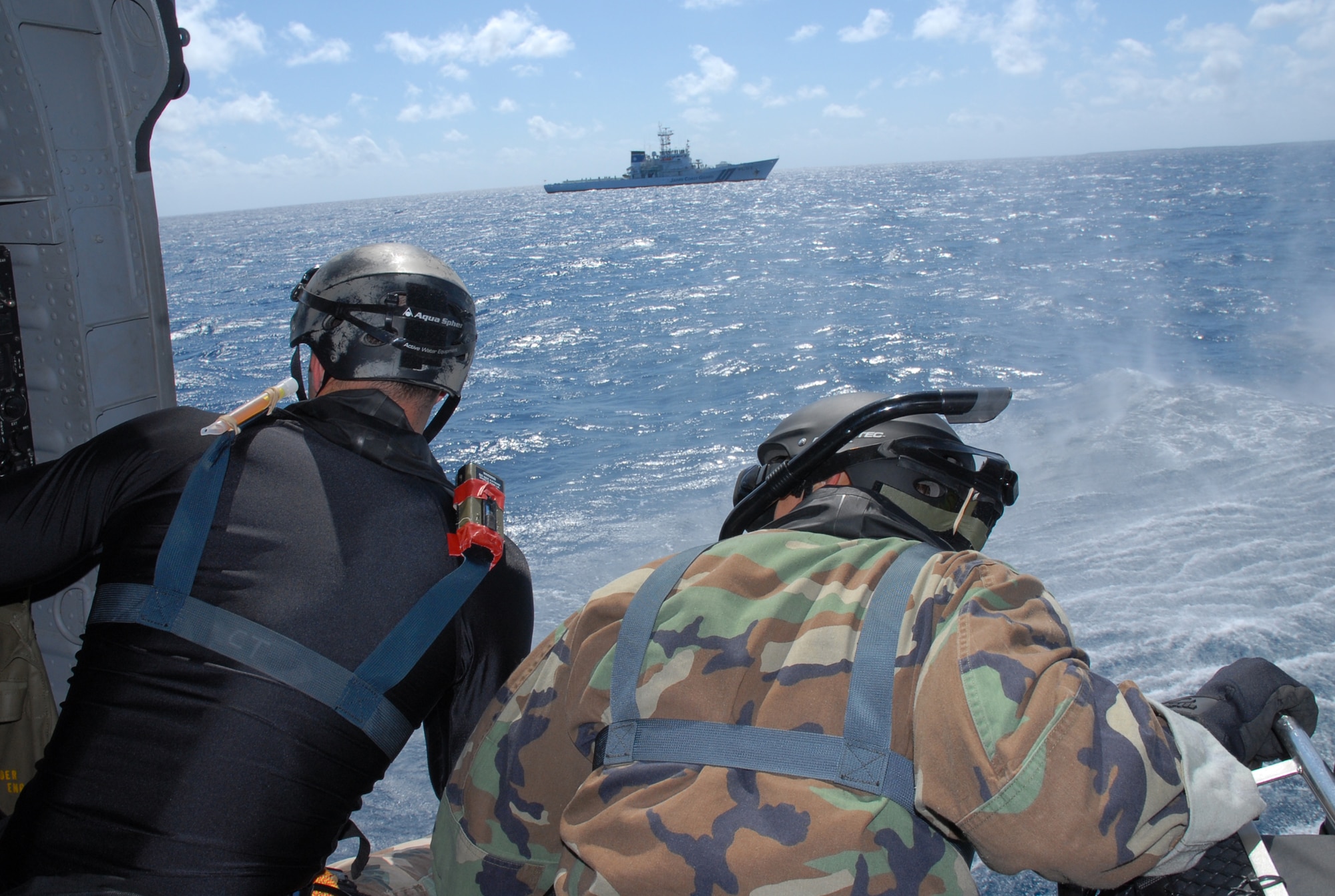 Staff Sgt. Jonathan Courtright and Senior Airman Oliver Smith, Pararescue Airmen assigned to the 31st Rescue Squadron scan the water below and prepare to rescue a downed pilot during a crisis management exercise, off the coast of Okinawa Oct. 8, 2008. Members of the 18th Wing and Japanese Coast Guard rehearsed response procedures for a simulated over the water aircraft accident. (U.S. Air Force photo/Staff Sgt. Chrissy Best)
