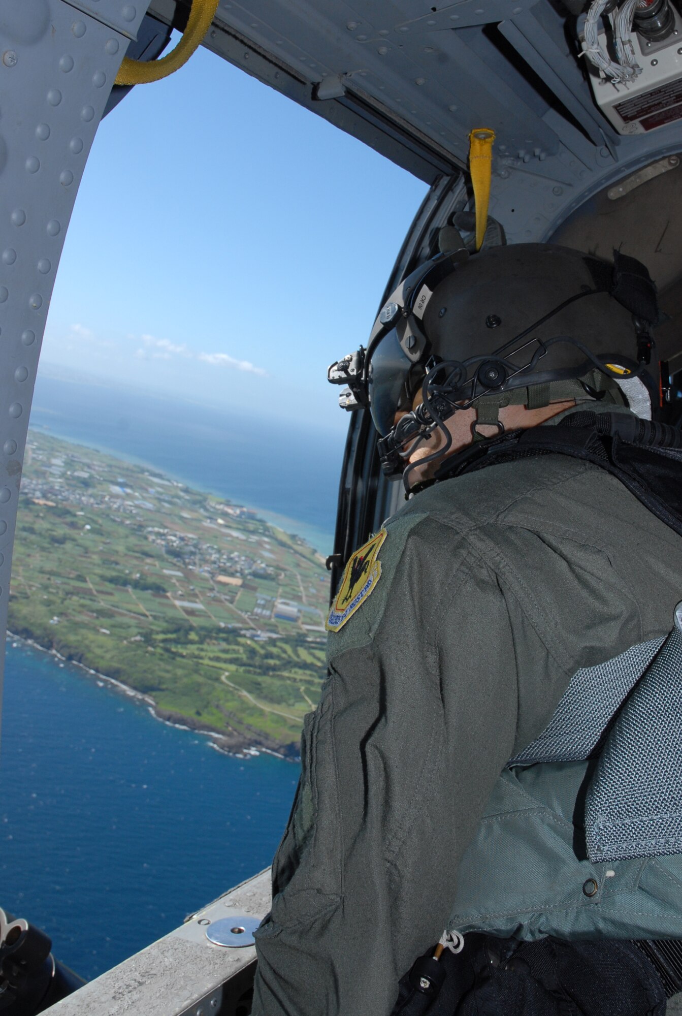 Staff Sgt. Justin Schramm, an aerial gunner assigned to the 33rd Rescue Squadron scans the sky and water below from an HH-60 prior to a crisis management exercise  off the coast of Okinawa Oct. 8, 2008. Members of the 18th Wing and Japanese Coast Guard rehearsed response procedures for a simulated over the water aircraft accident. (U.S. Air Force photo/Staff Sgt. Chrissy Best)