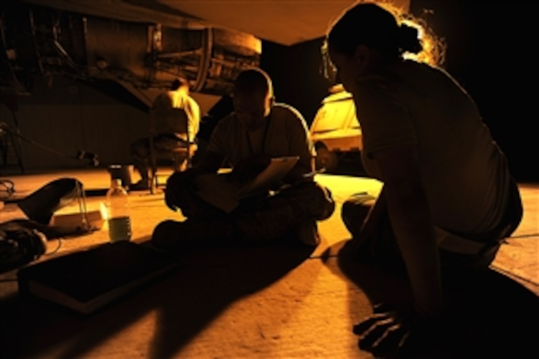 U.S. Air Force Staff Sgt. Danny Shaw, left, installs safety wiring as Staff Sgt. Nathan Gadbois, middle, and Airman 1st Class Jessica Guinn look through a technical order while performing maintenance on an F-16 Fighting Falcon's propulsion system on Joint Base Balad, Iraq, Oct. 6, 2008. Shaw, Gadbois and Guinn, all aerospace propulsion journeymen, are assigned to the 332nd Expeditionary Aircraft Maintenance Squadron. 