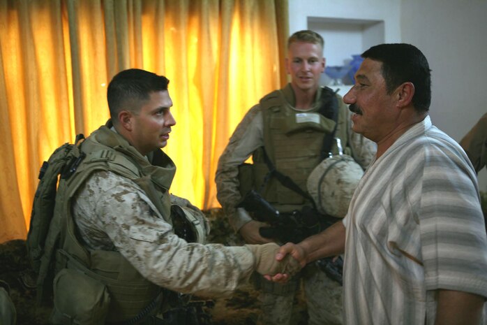 Staff Sgt. Jaime Benevides, platoon sergeant, Provisional Rifle Platoon 3, greets Yaser Humady Khatlan, with 2nd Lt. Randy Blowers, platoon commander, PRP 3, in Yaser's home in Rawah, Iraq, Oct. 10.  With PRP 3 working on improving Traffic Control Point 3 in Rawah, the Marines took time to visit several residents in Rawah to introduce themselves.::r::::n::